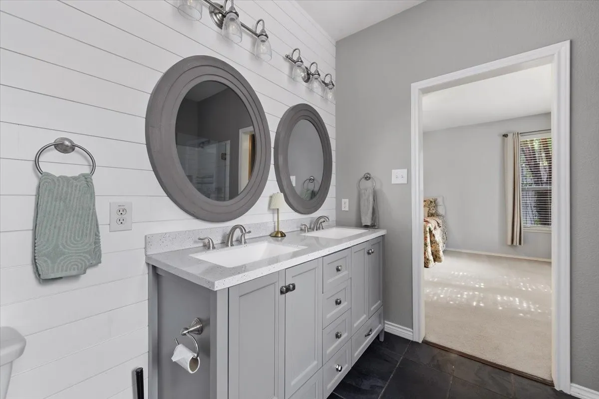 Spa-inspired primary bathroom featuring a dual-sink vanity with white quartz countertop, soft-close cabinetry, and polished nickel hardware