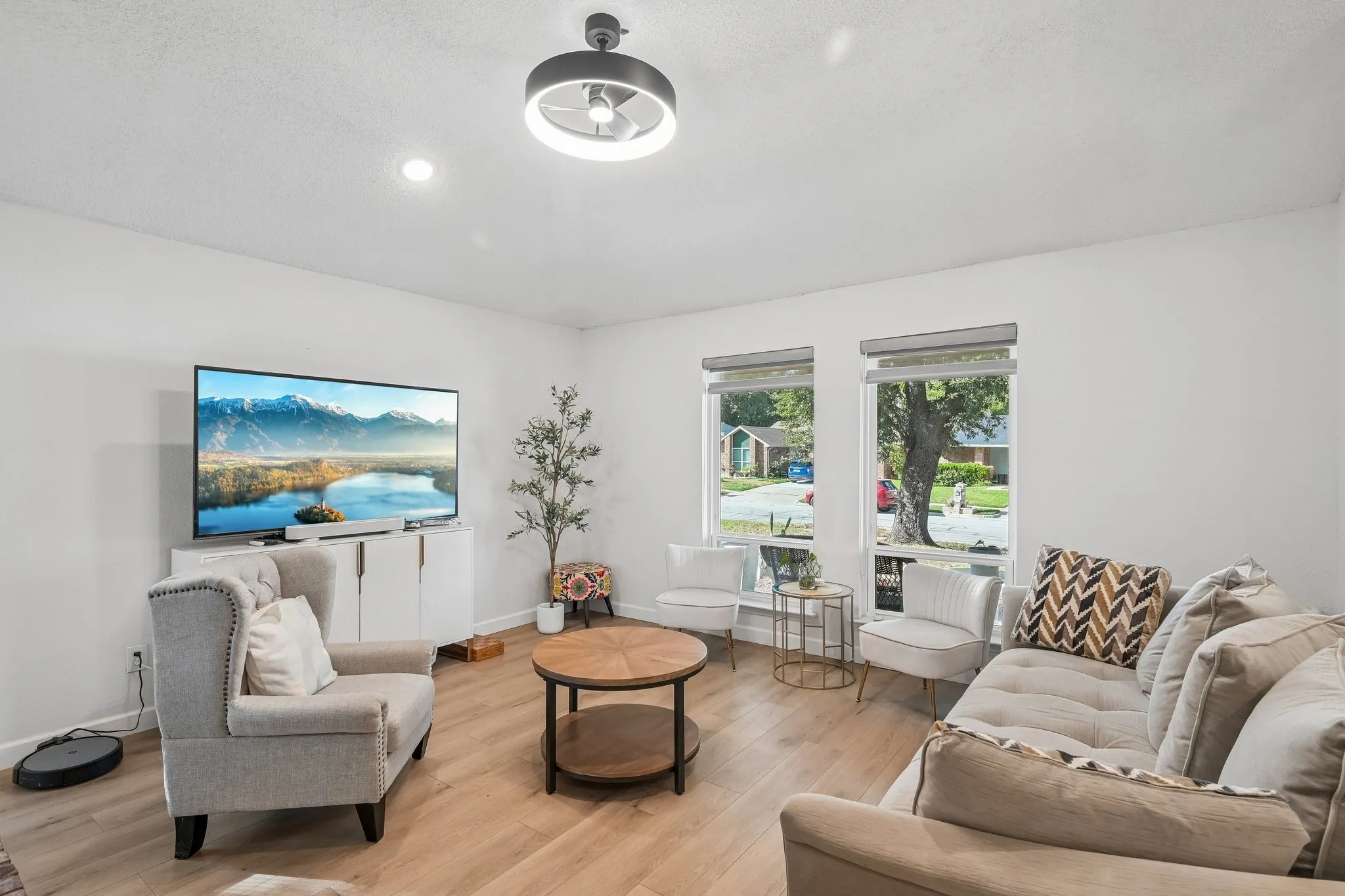 Living room has updated ceiling fan and custom window shades