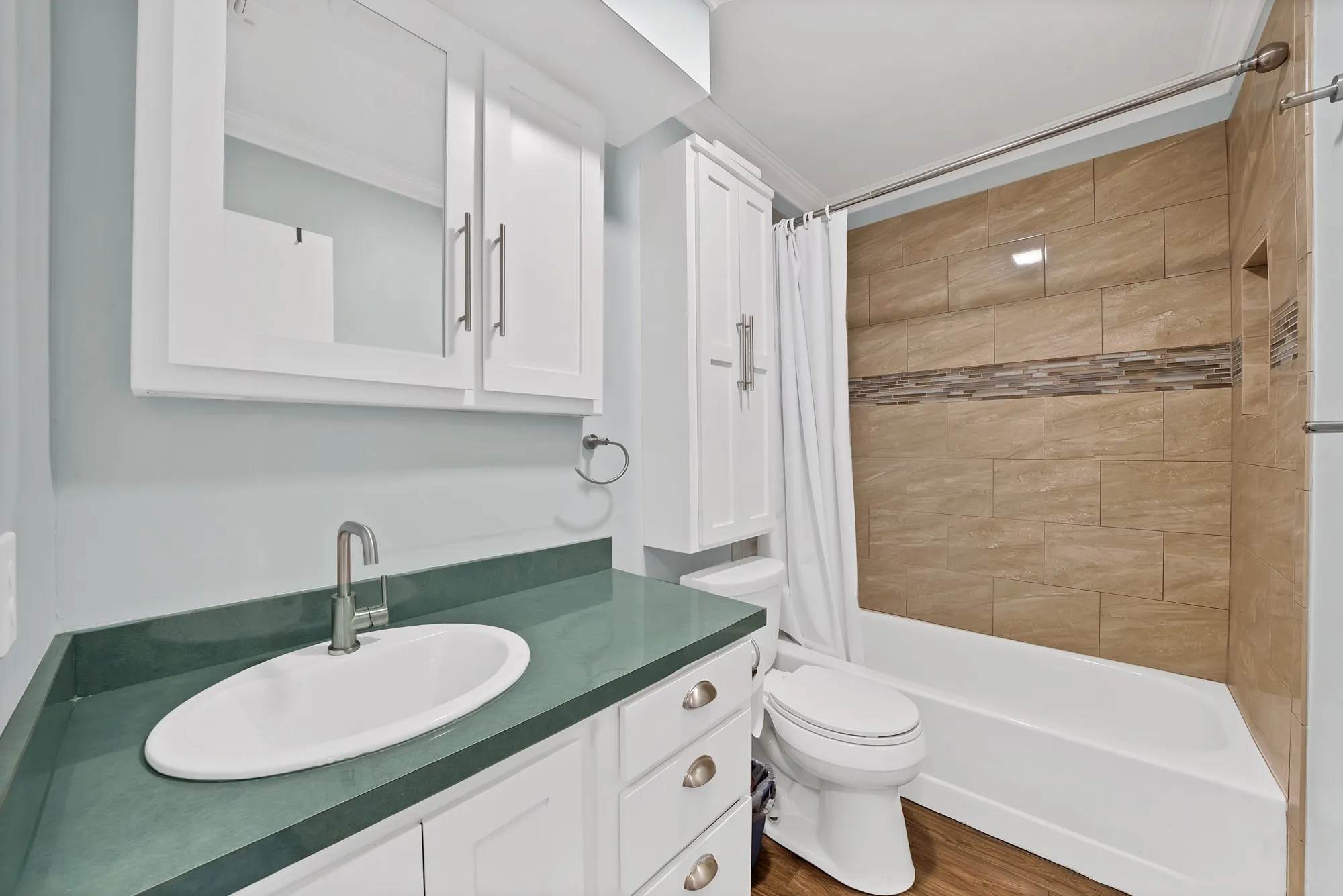 White shaker vanity with a green countertop and oval undermount sink