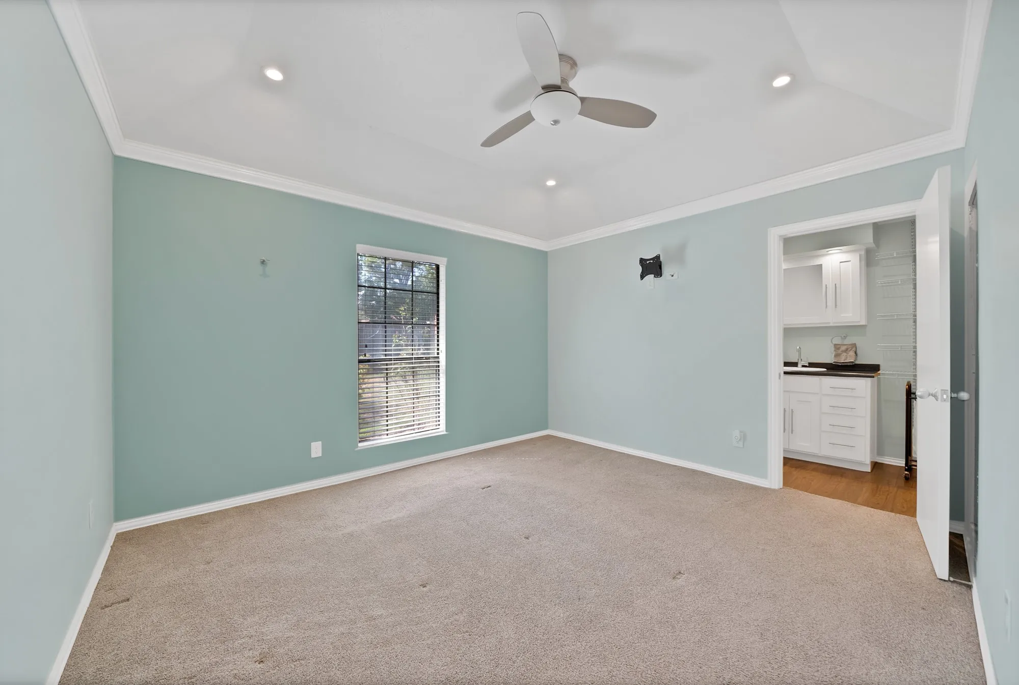Tray ceiling with recessed lighting, ceiling fan, and carpeted flooring
