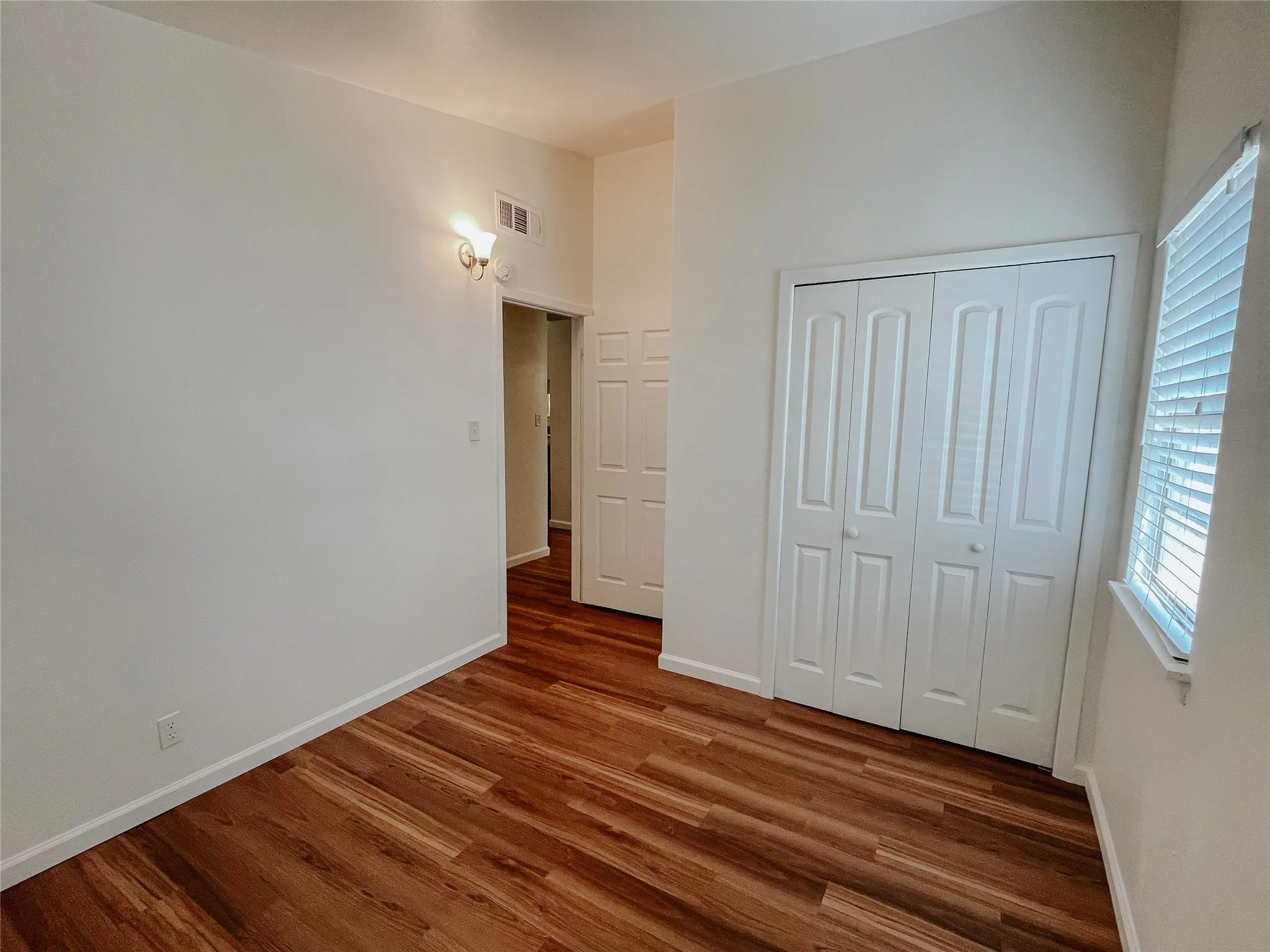 Unfurnished bedroom with a closet and dark hardwood / wood-style flooring