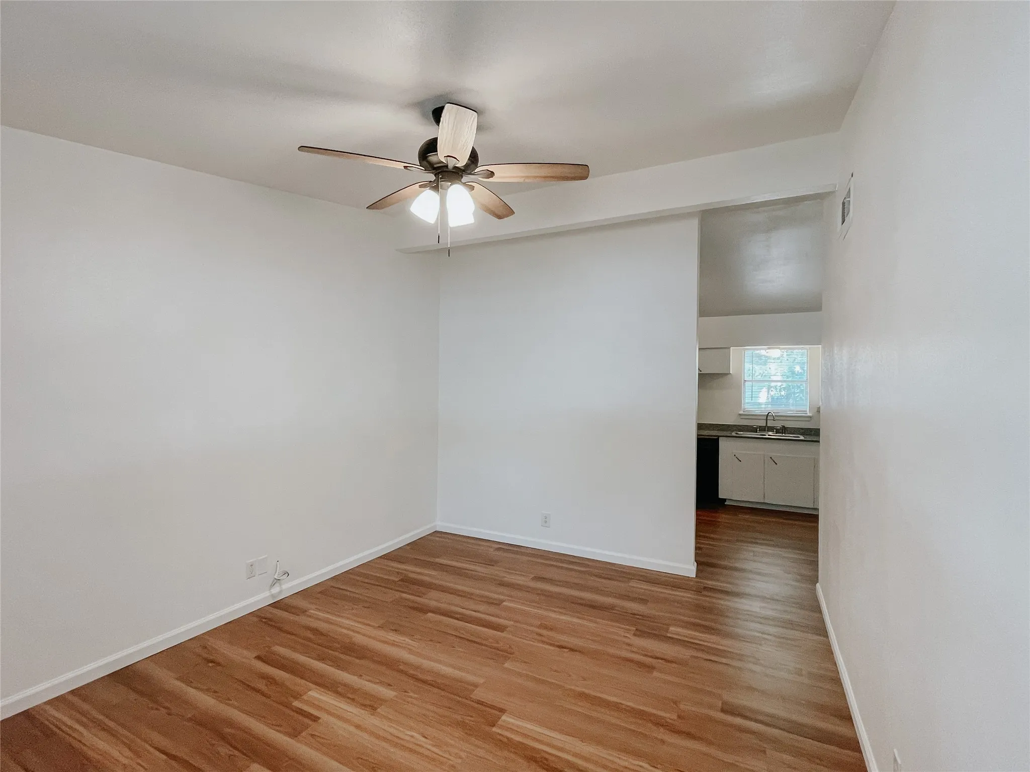 Spare room with sink, light wood-type flooring, and ceiling fan
