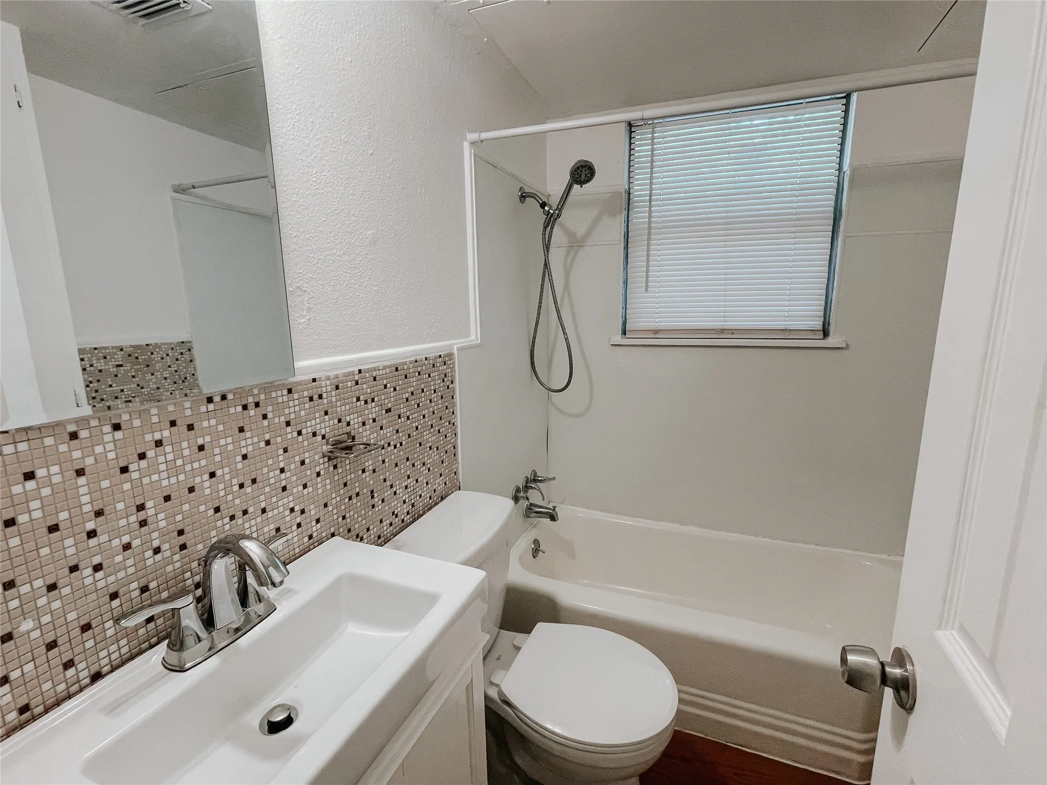 Full bathroom featuring tile walls, shower / bathing tub combination, vanity, and toilet