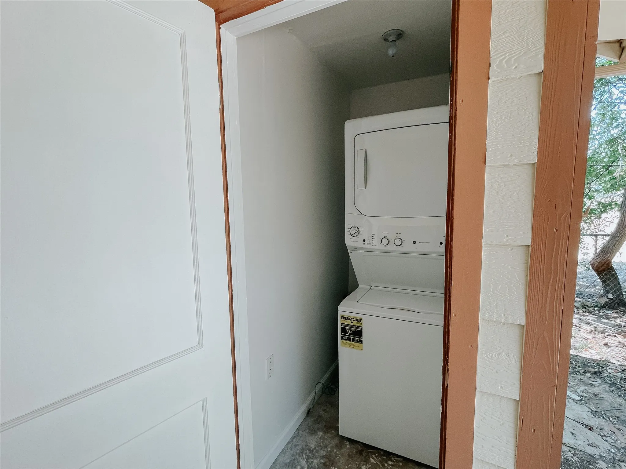 Washroom featuring stacked washing maching and dryer