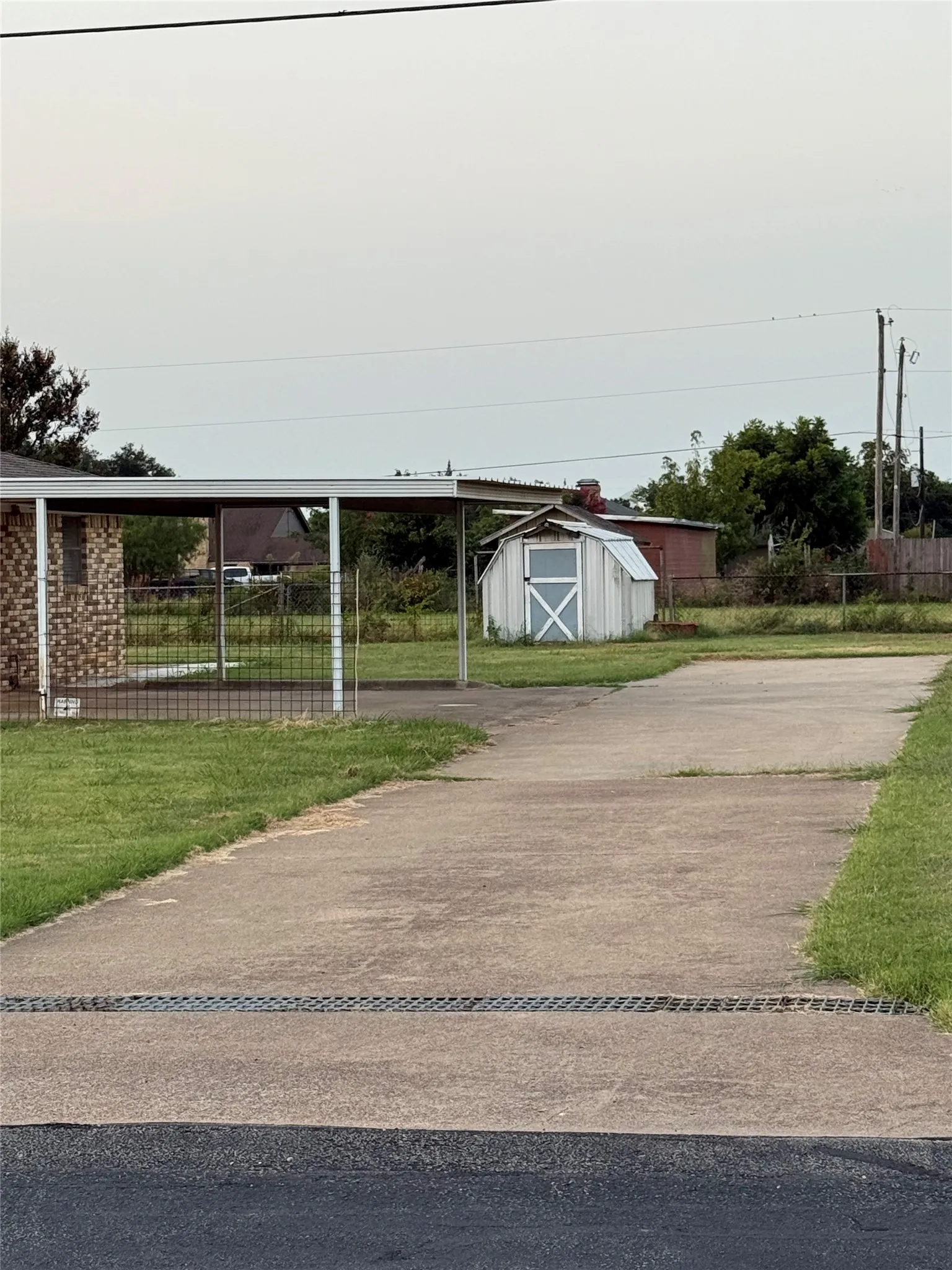 View of parking featuring a storage shed