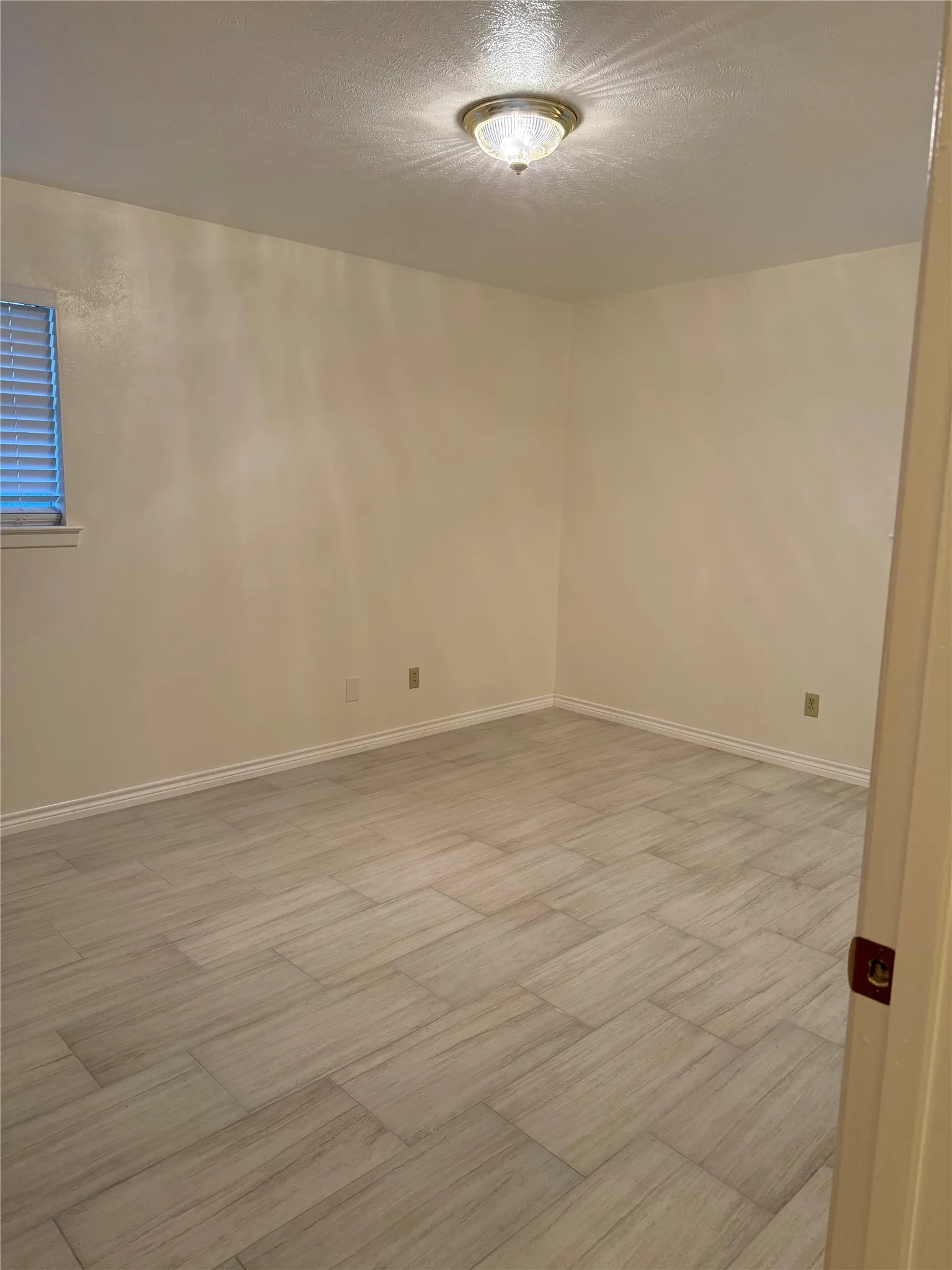 Spare room featuring a textured ceiling and light wood-type flooring