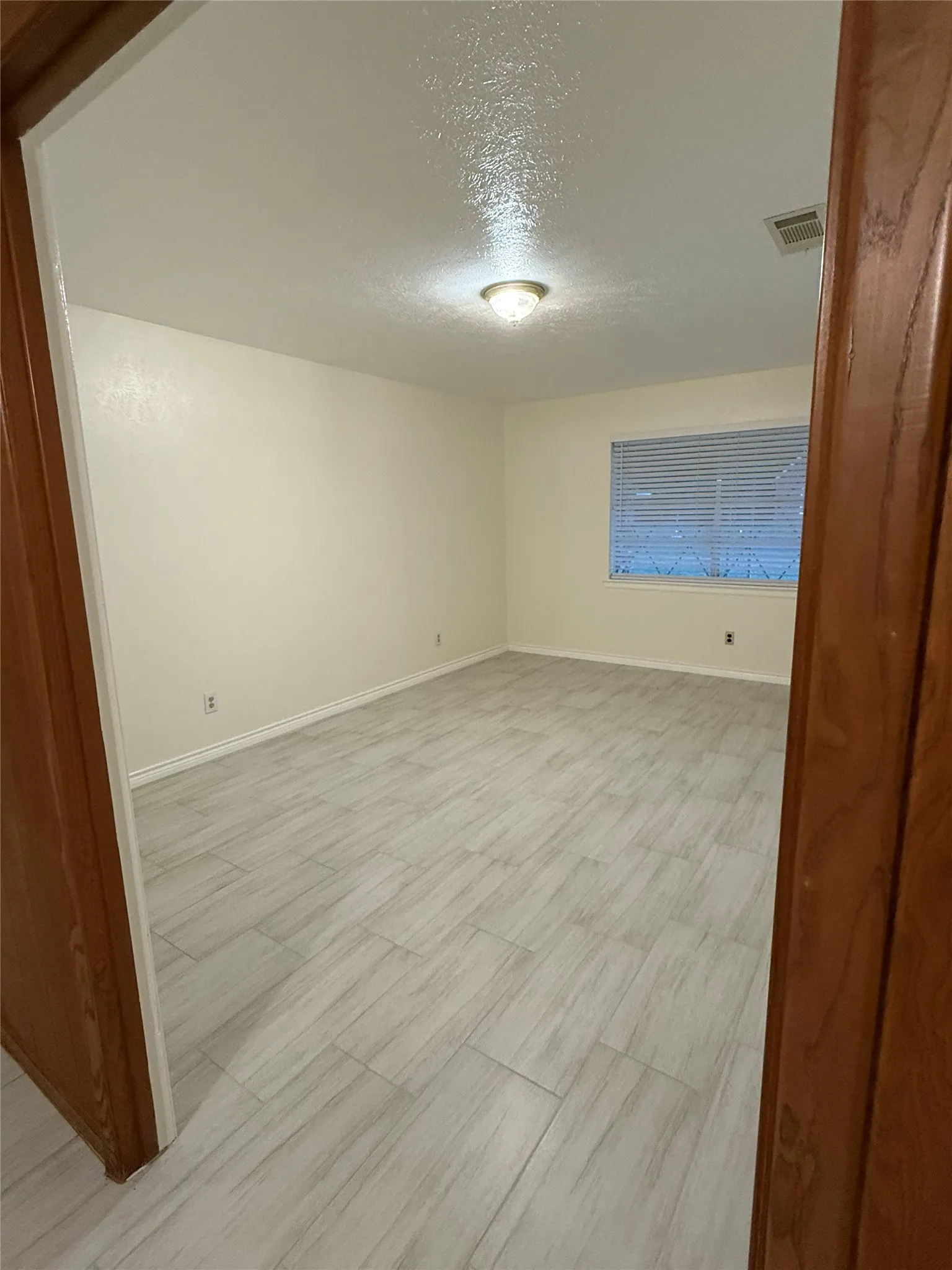 Unfurnished room featuring a textured ceiling and light wood-type flooring