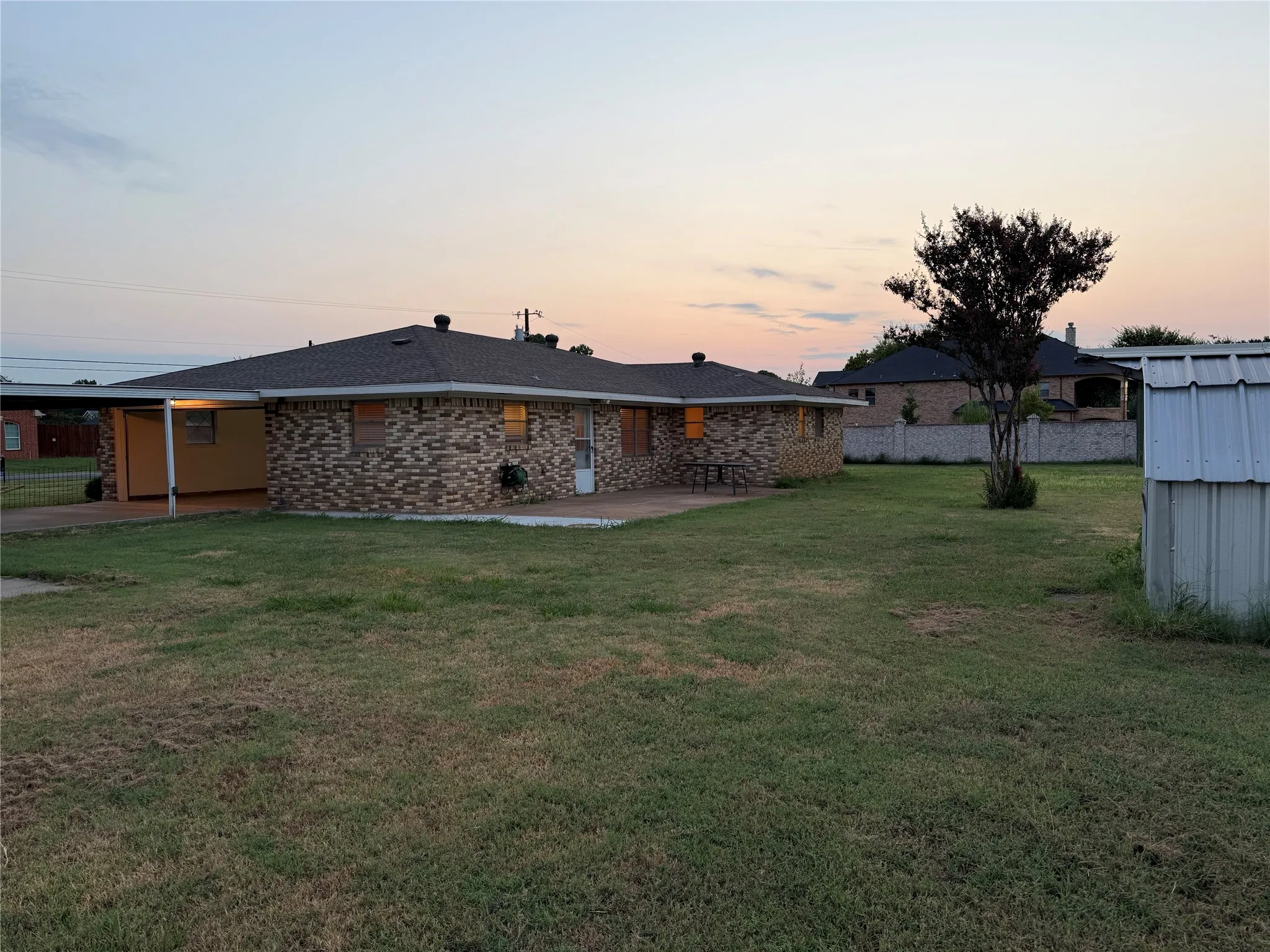 Back of house with a patio and brick siding