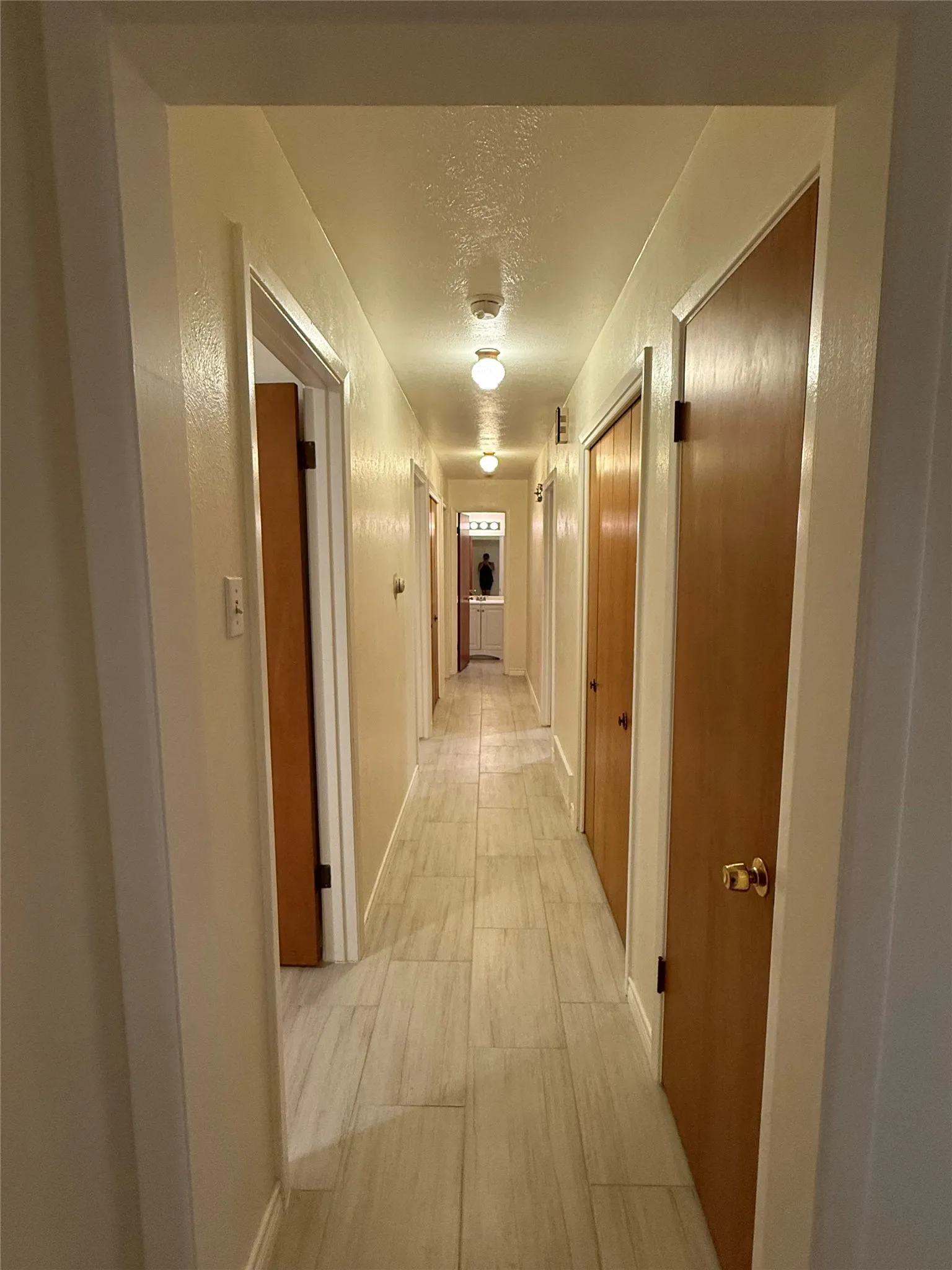 Corridor featuring light wood-style flooring and a textured ceiling