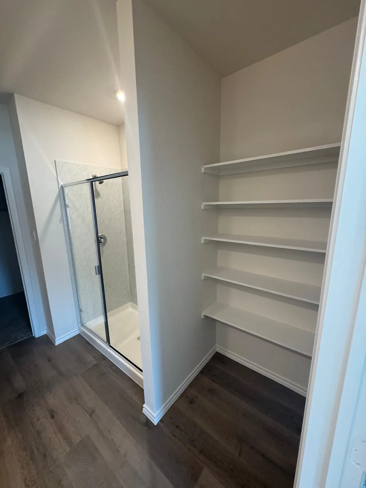 Full bathroom featuring a stall shower and dark wood-type flooring