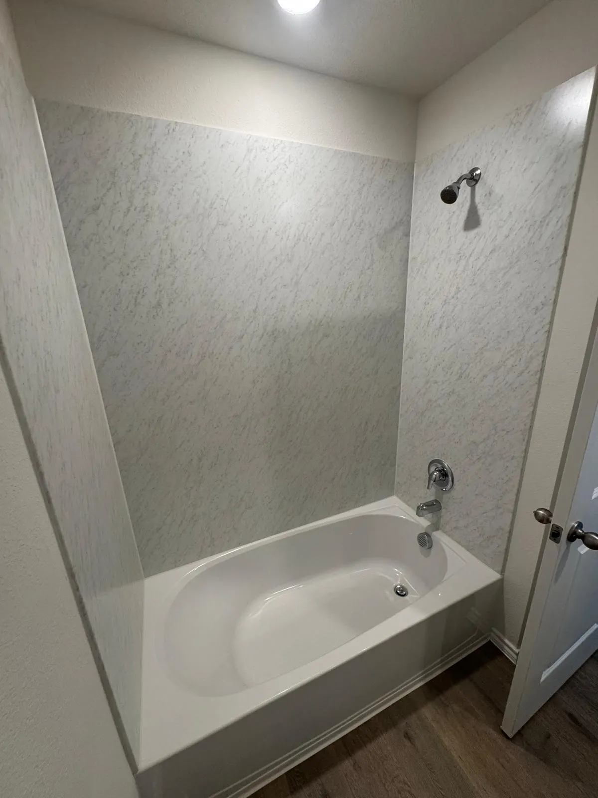 Bathroom with wood finished floors and shower / tub combination