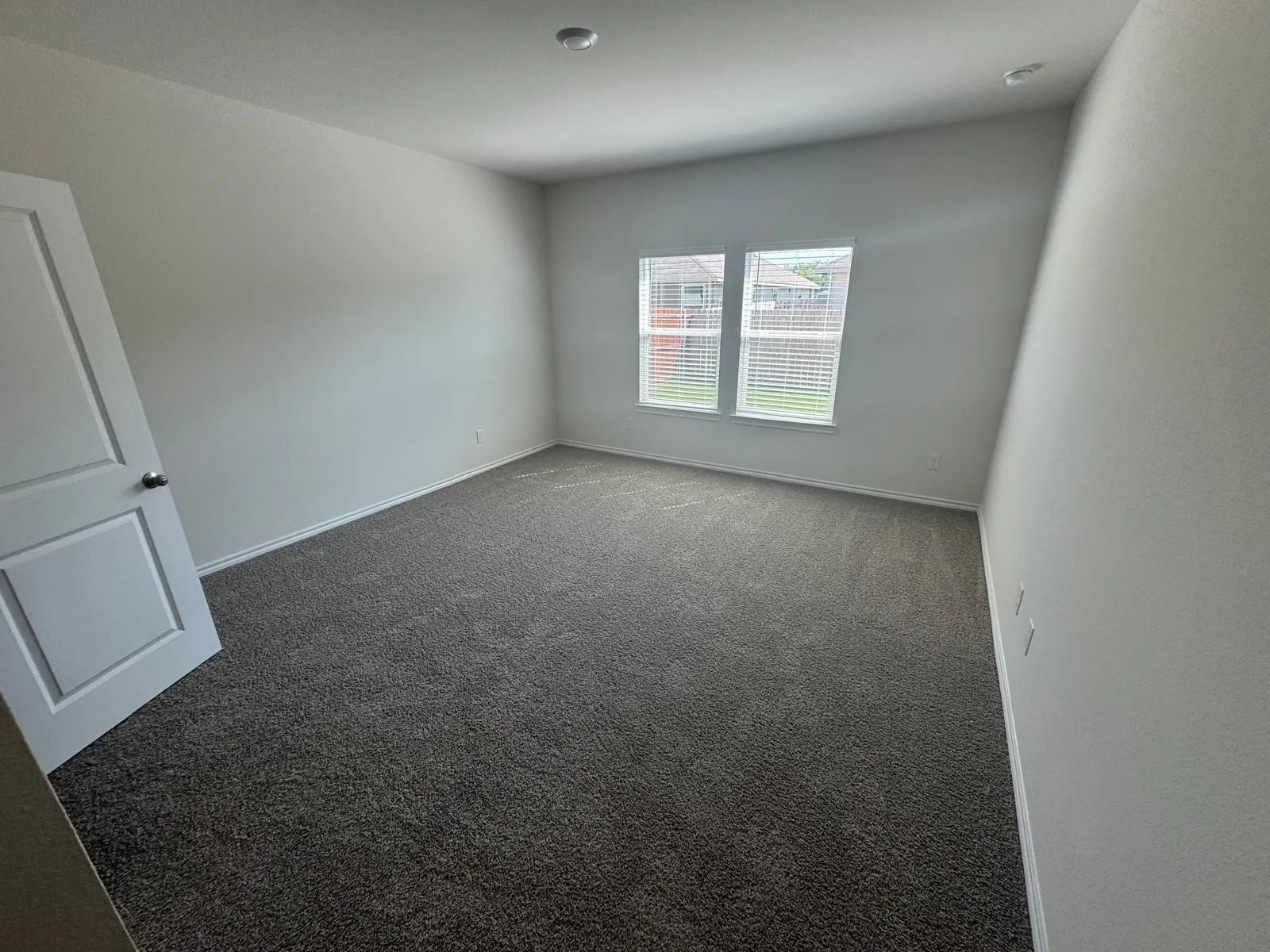 Carpeted spare room with baseboards