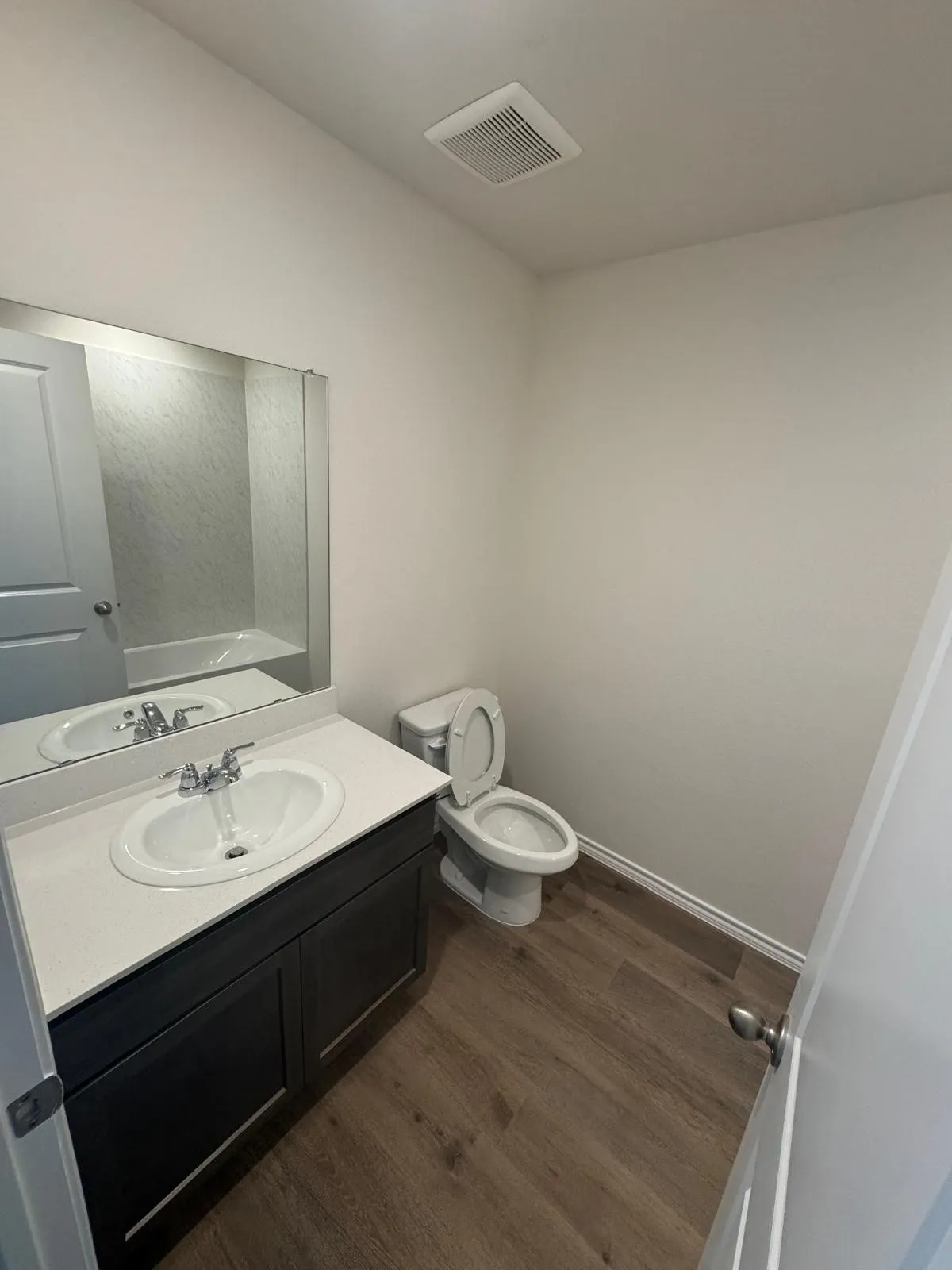 Half bath with dark wood-style floors and vanity