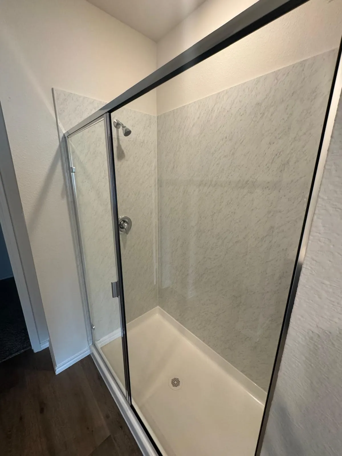 Bathroom featuring dark wood-style flooring and a shower stall