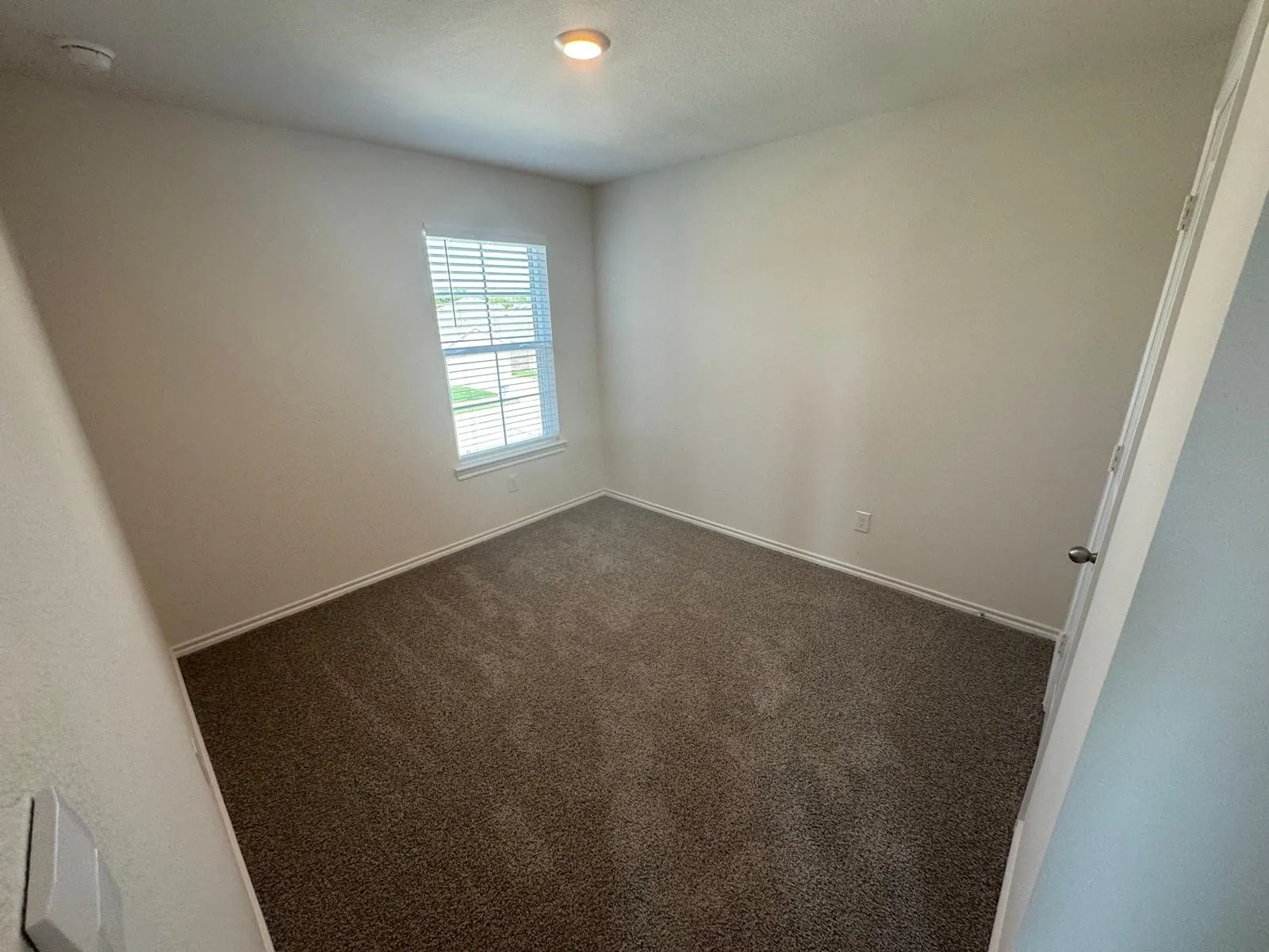 Carpeted spare room with baseboards