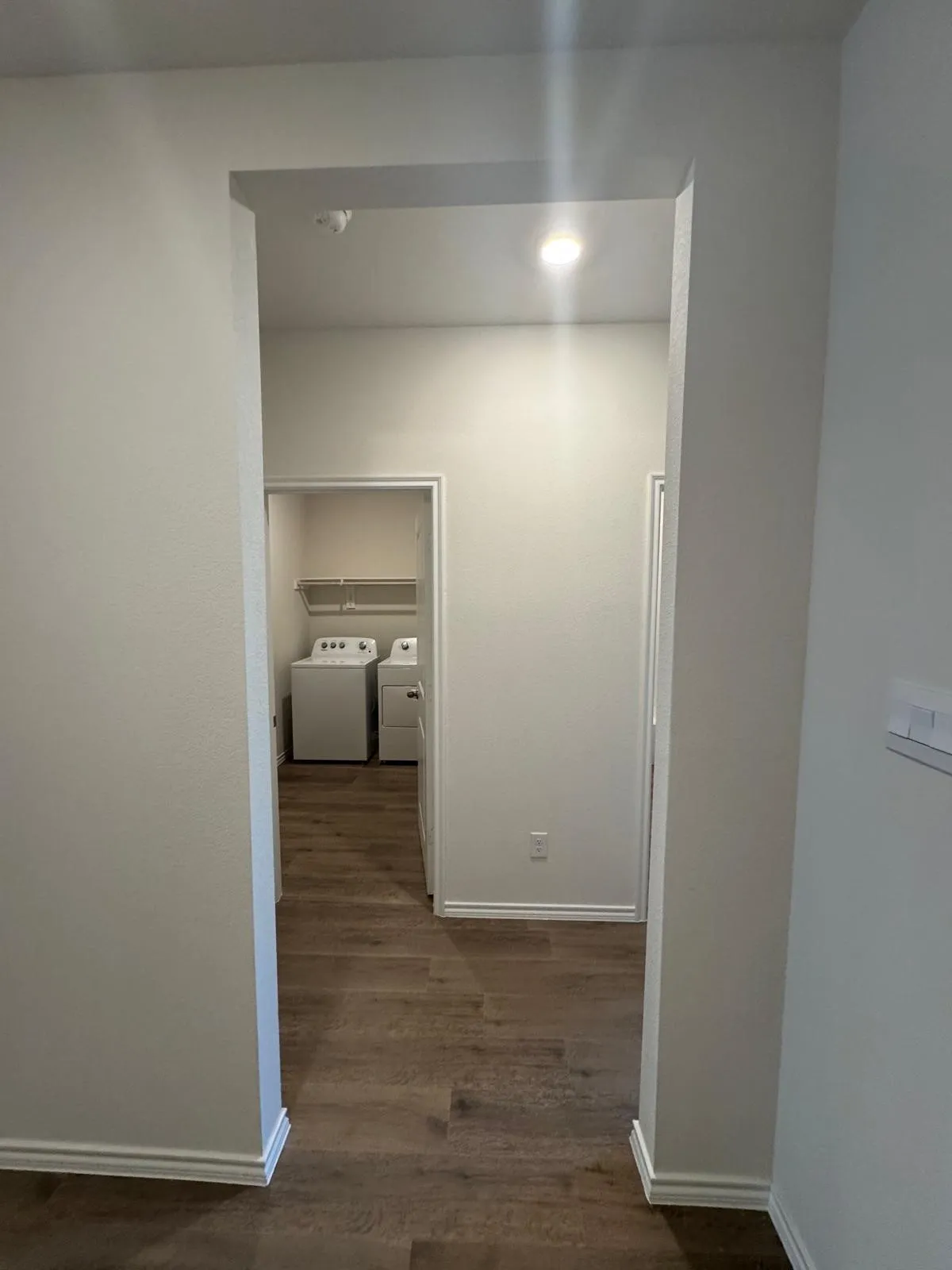 Hall featuring dark wood-style flooring and separate washer and dryer