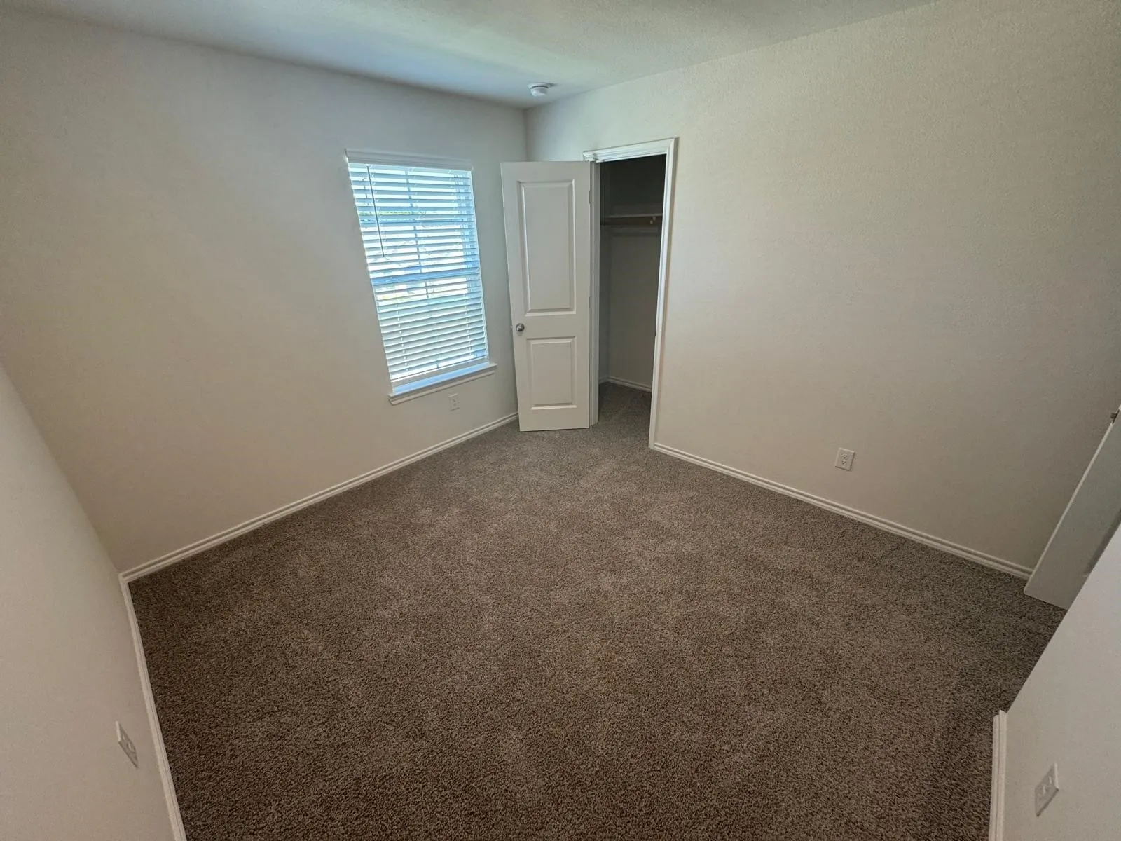Unfurnished bedroom featuring dark carpet and a closet