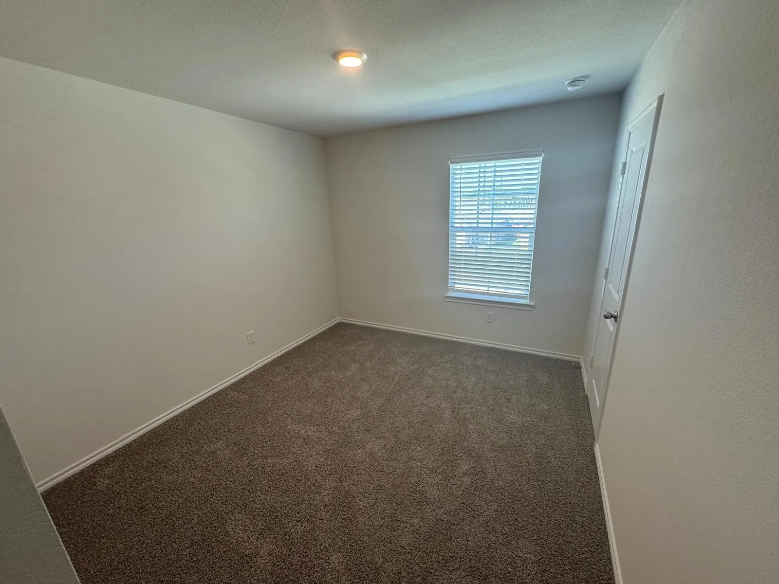 Unfurnished room with dark colored carpet and a textured ceiling