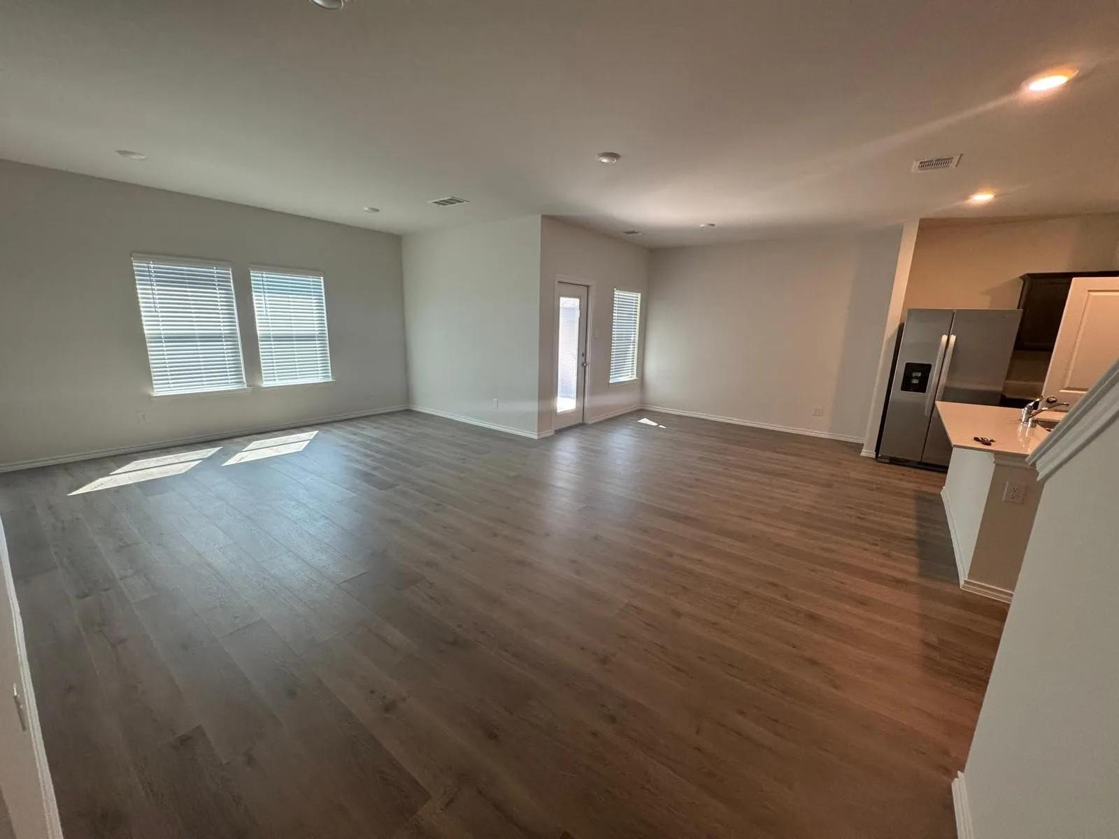 Unfurnished living room with recessed lighting, dark wood-style flooring, and plenty of natural light