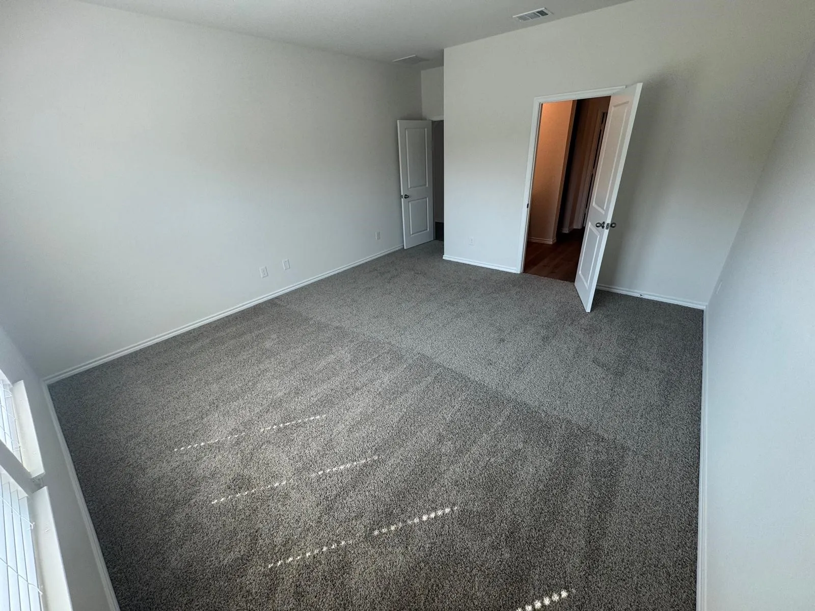 Unfurnished bedroom with carpet floors and baseboards