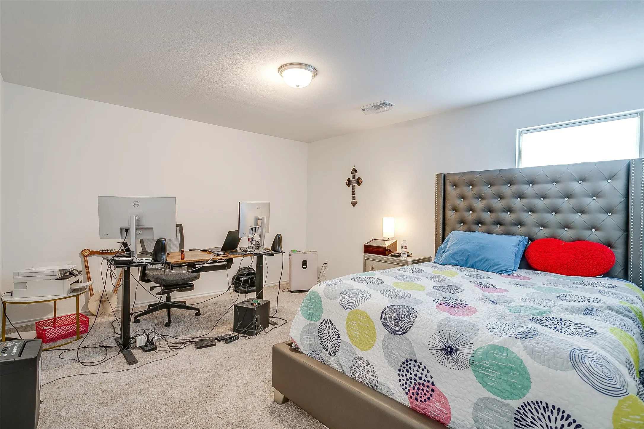 Carpeted room featuring a ceiling-mounted light fixture, white walls, and a window providing natural illumination
