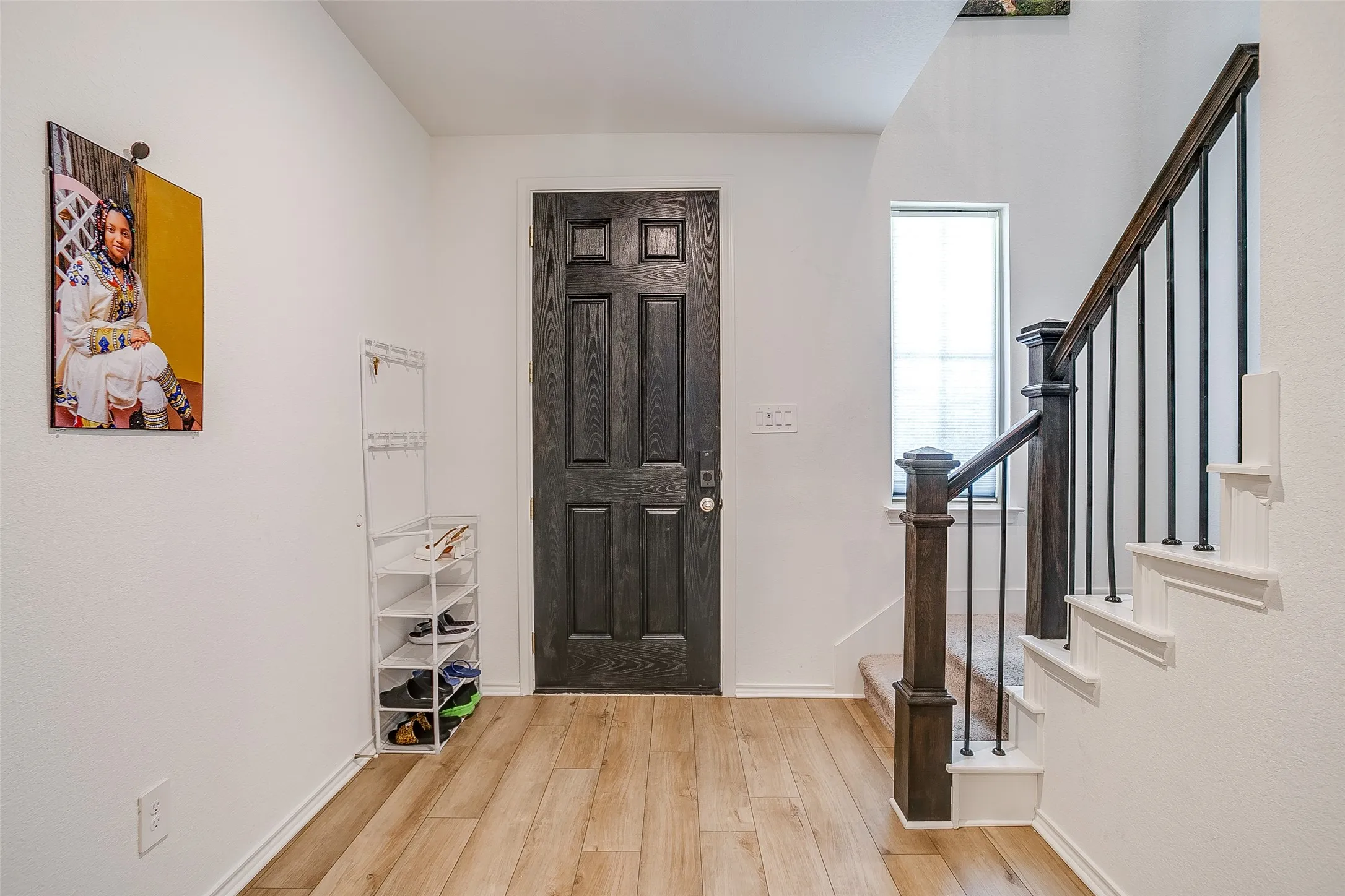 Wood-finish flooring with a contrasting dark paneled door