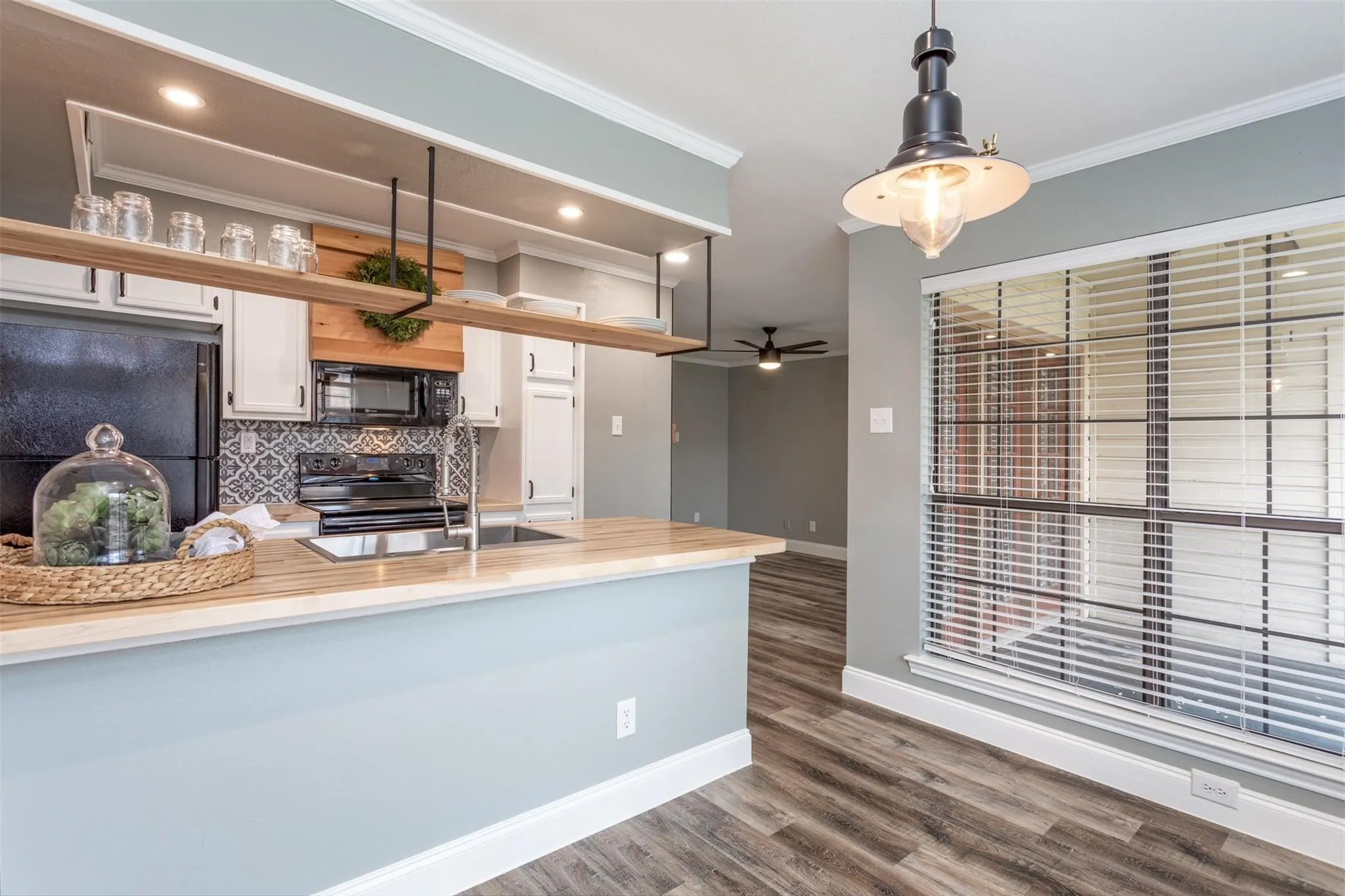View of kitchen from the dining area.  Open cabinets/shelf, butcher block countertops.