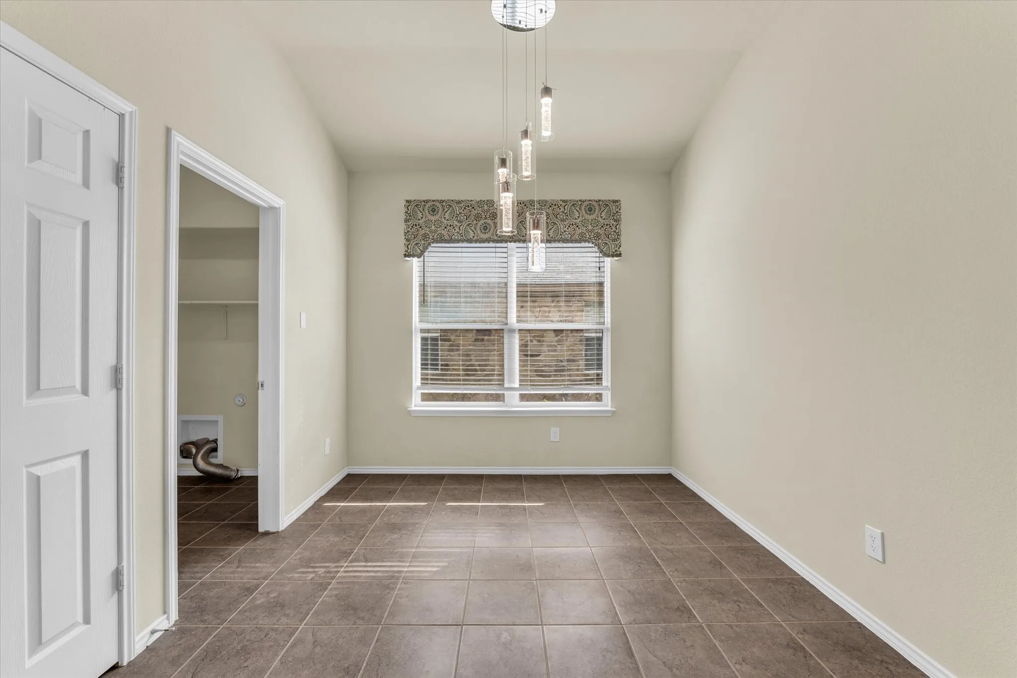 Recessed window with blinds, modern pendant lighting fixture, and durable tile flooring
