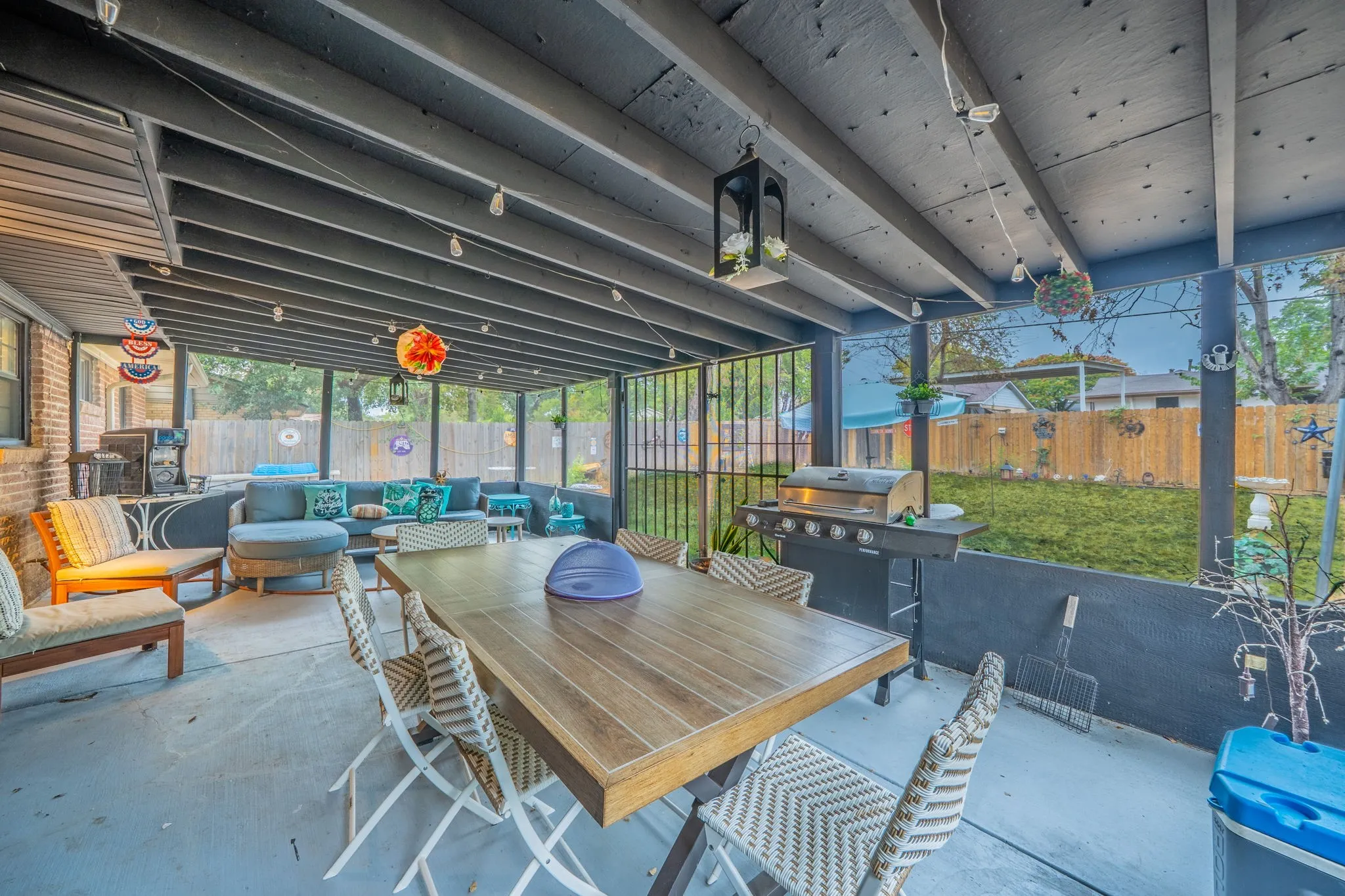 Screened patio featuring a solid roof, concrete flooring, and an exposed brick exterior wall