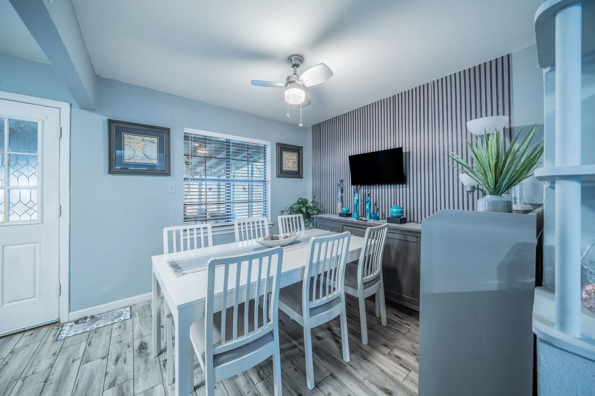 Wood-finish flooring complementing a white door with decorative glass