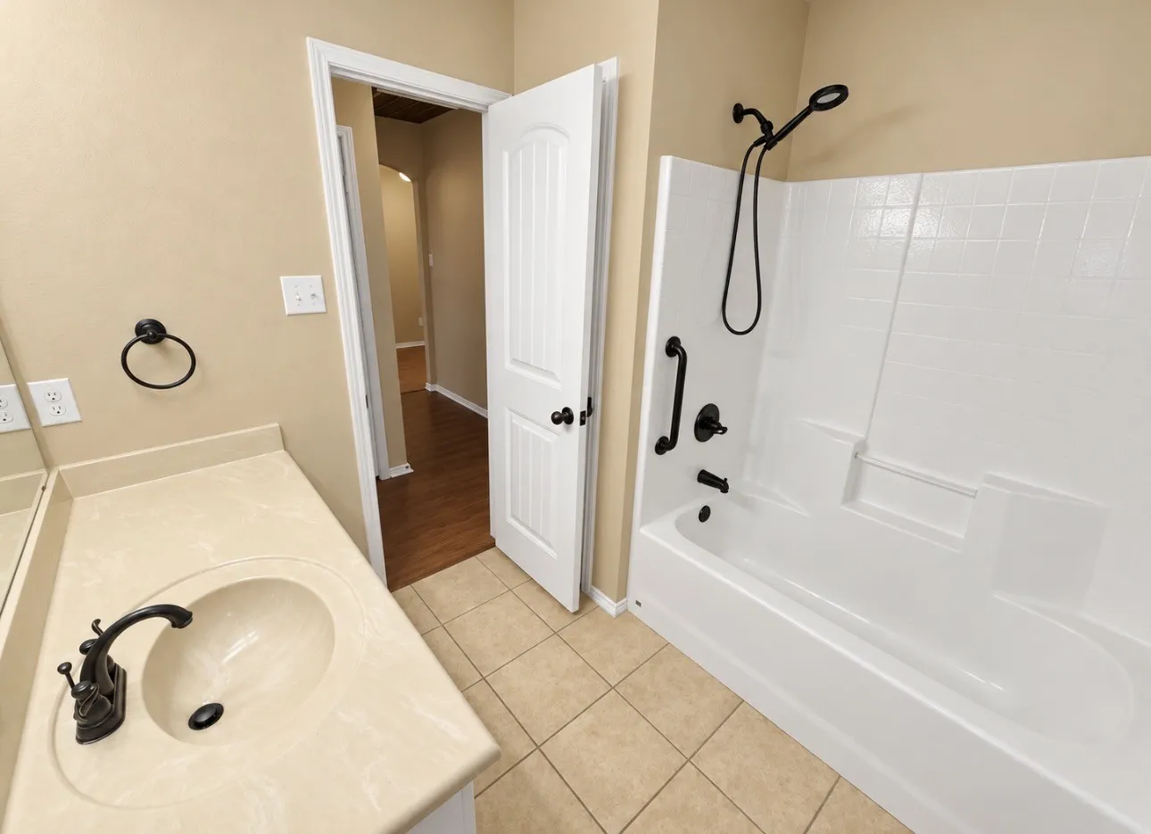 Built-in bathtub with shower, integrated shelving, and dark bronze fixtures