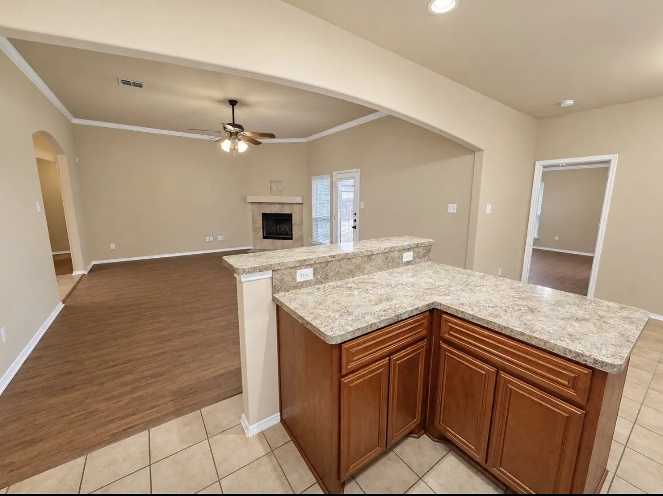 Kitchen island with stone-finish countertop and wood cabinetry