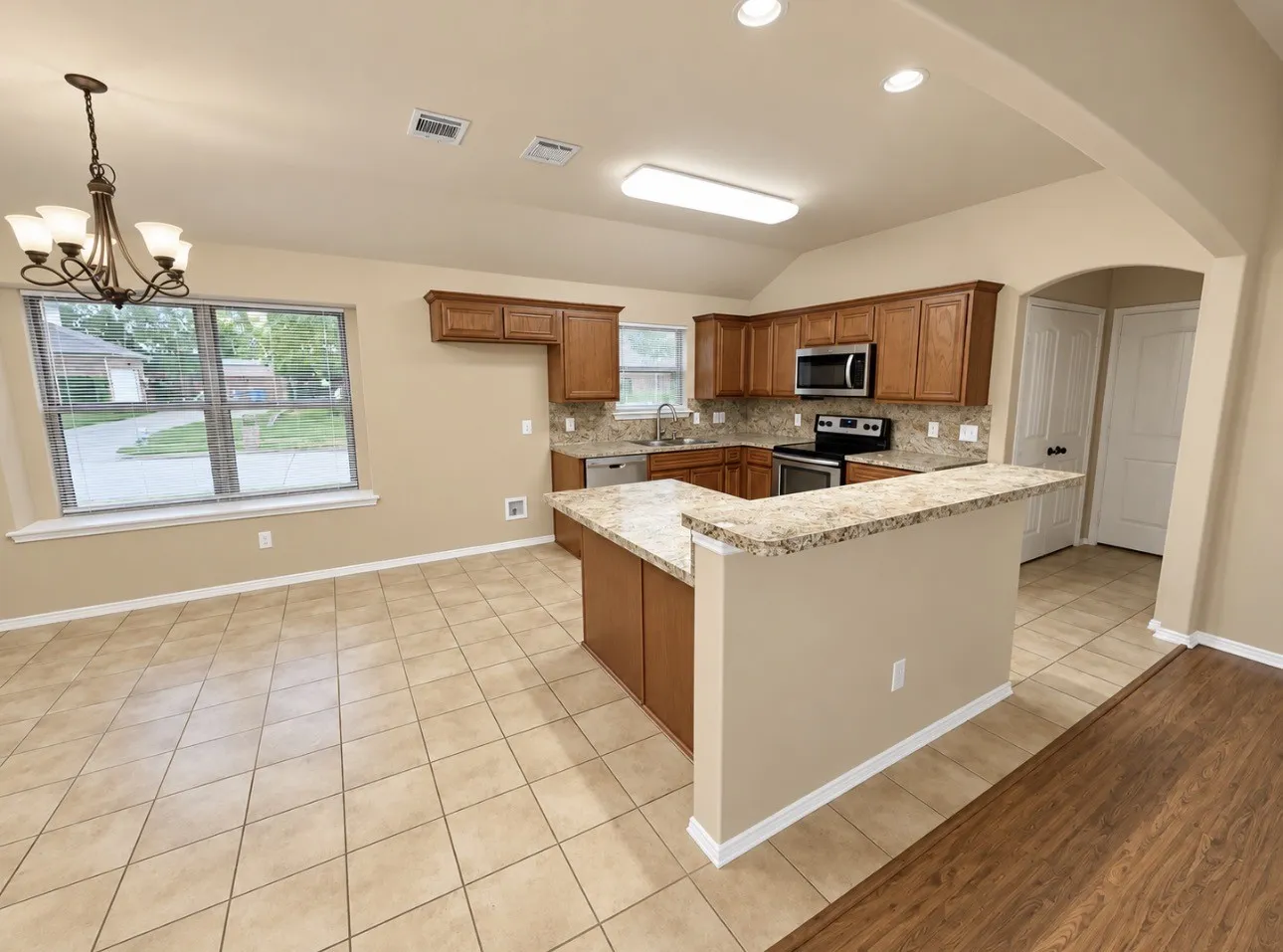 Kitchen featuring wood cabinetry, stainless steel appliances, and a granite-style countertop