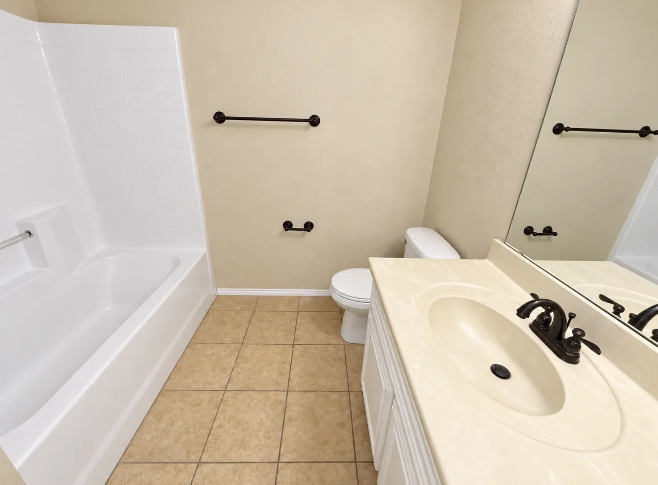 White vanity with integrated sink, bronze-finish faucet, and coordinating hardware