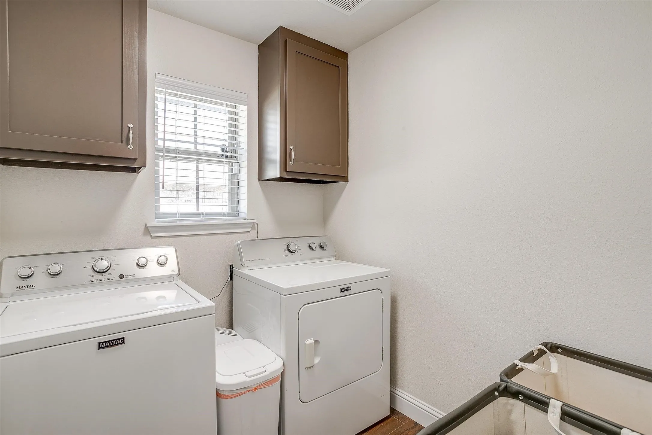 Built-in upper cabinetry with brushed nickel hardware and a window with blinds