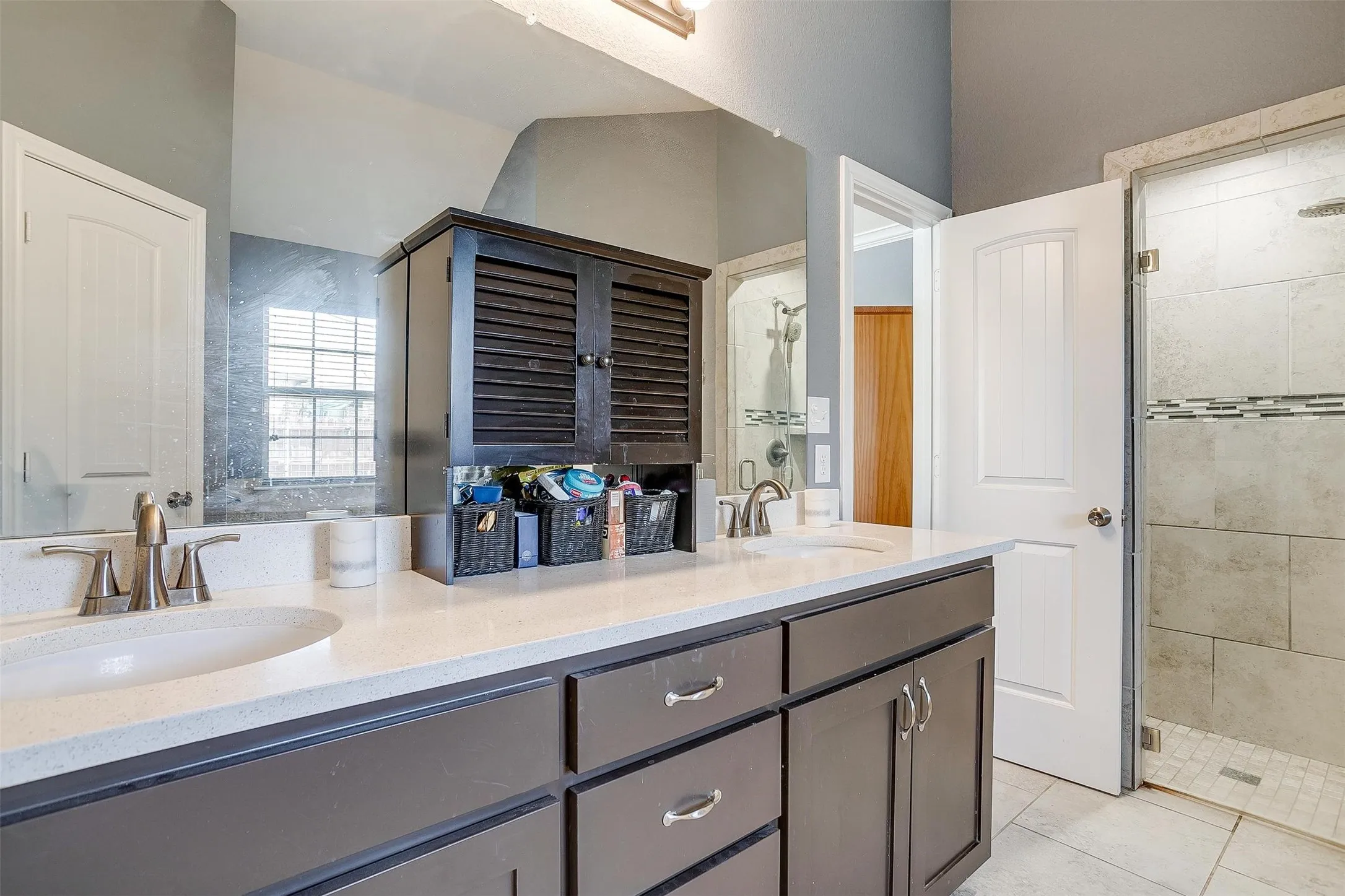Dual vanity with white countertops, dark wood-finish cabinetry, and brushed nickel fixtures
