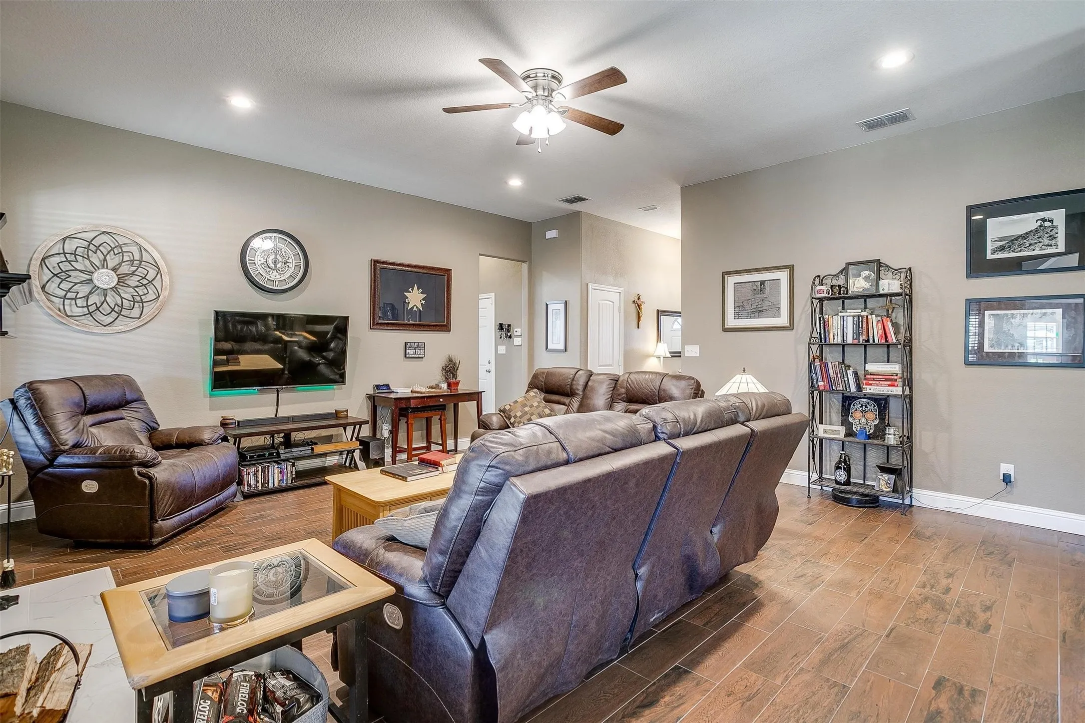 Spacious living area featuring wood-finish flooring, recessed lighting, and a ceiling fan