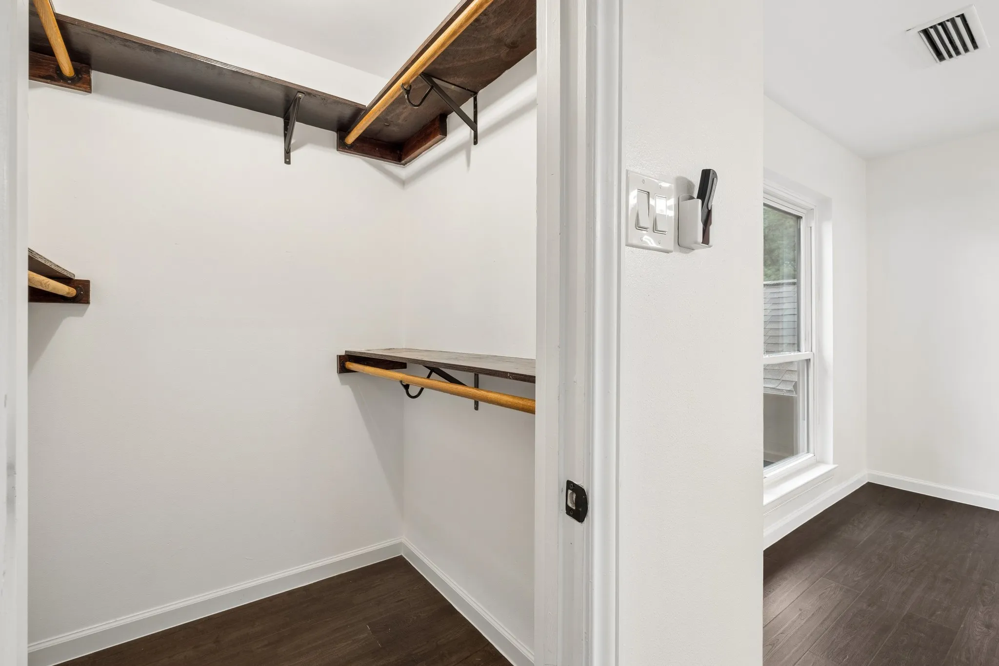 White walls with dark wood-finish flooring