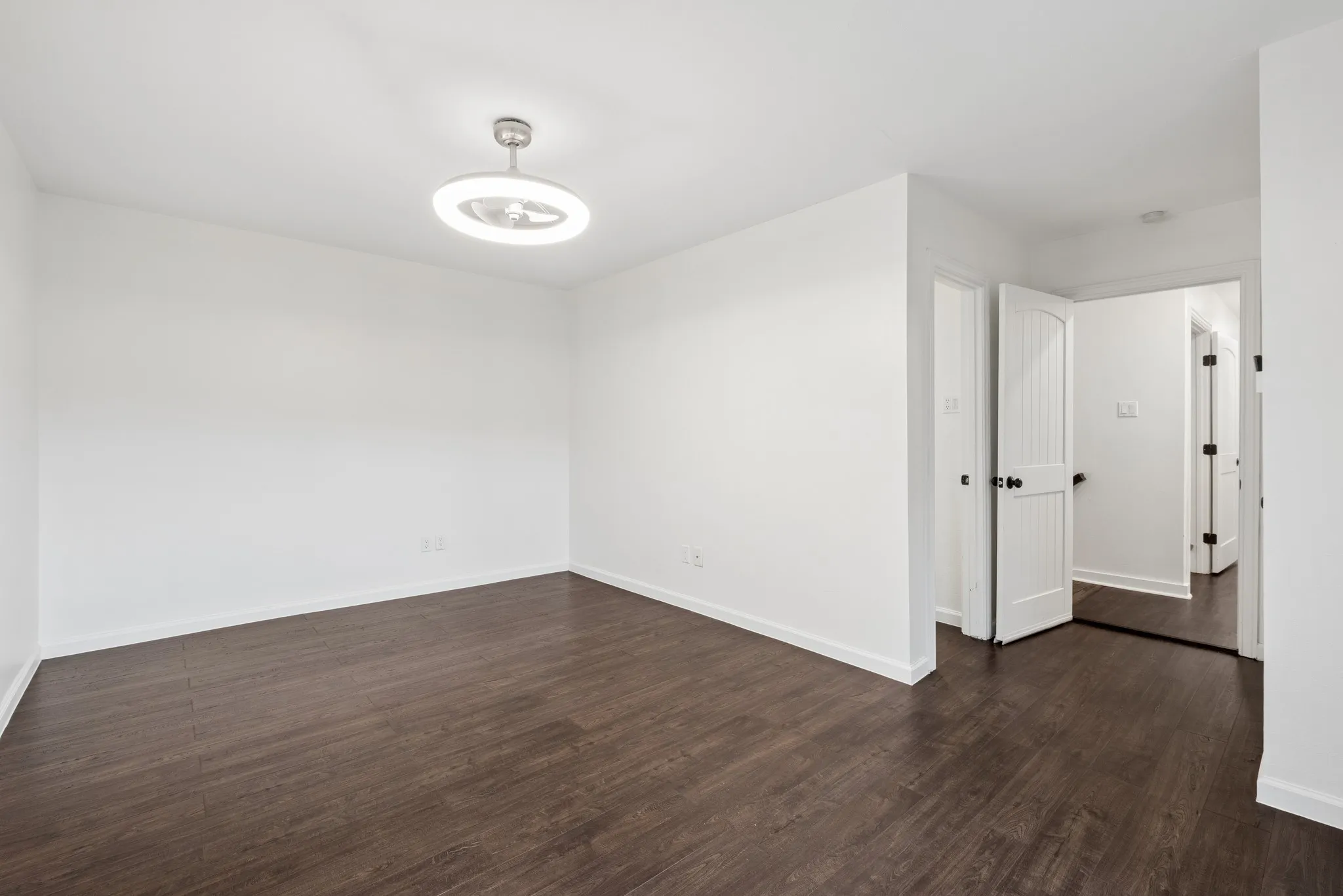Wood-finish flooring, white walls, and a modern ceiling fixture