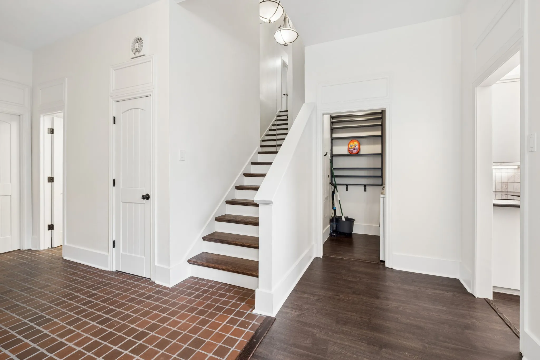Tile flooring, wood-finish flooring, staircase with wood treads, white paneled doors, built-in shelving