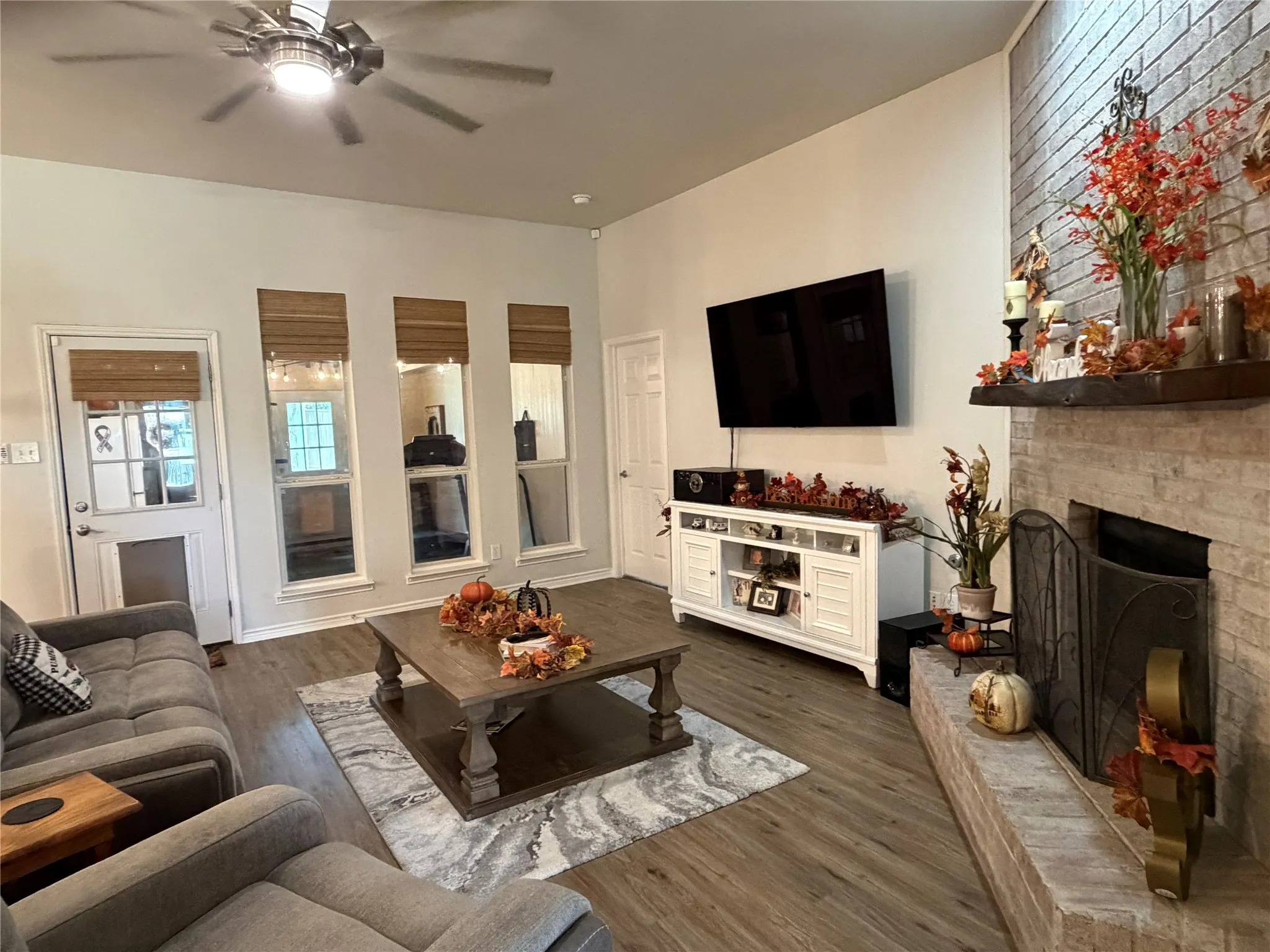 This Flows Seamlessly into a Warm and Welcoming Family Room, where a Cozy Brick Fireplace with a Wood Mantle Serves as the Perfect Centerpiece for Gatherings