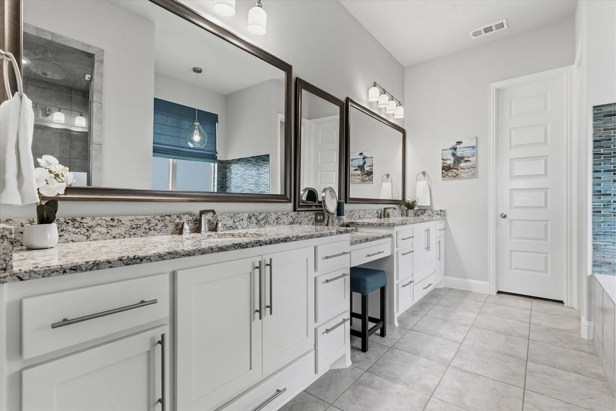 Primary bath with frameless shower, garden tub, dual sinks, separate vanities, and a large walk in closet.