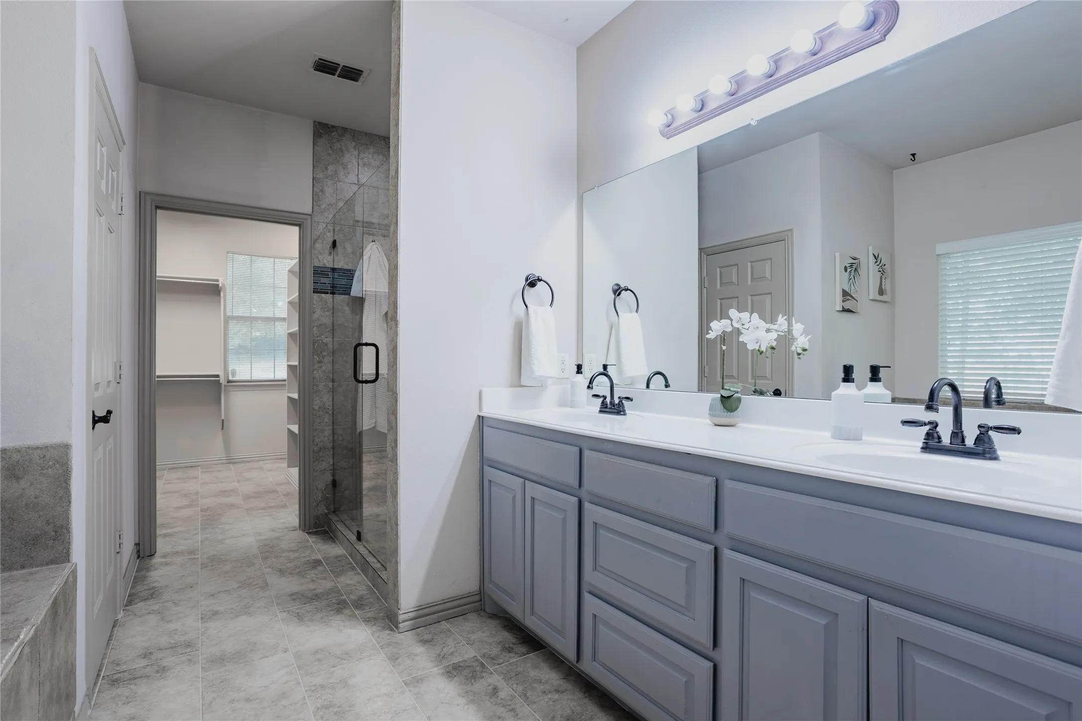Double vanity with white countertops, undermount sinks, and matte black fixtures