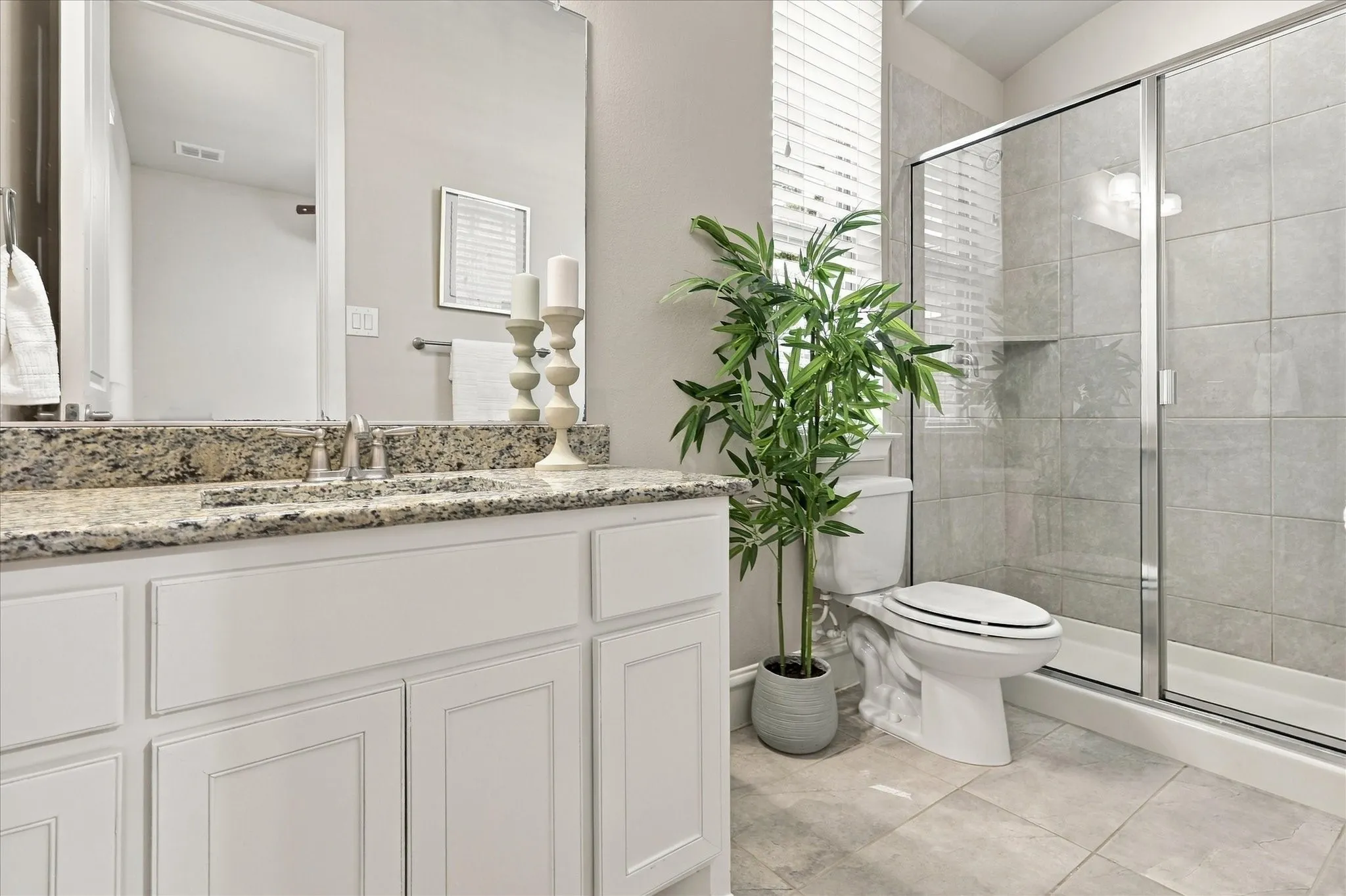 First floor guest bathroom with walk-in shower and granite counters