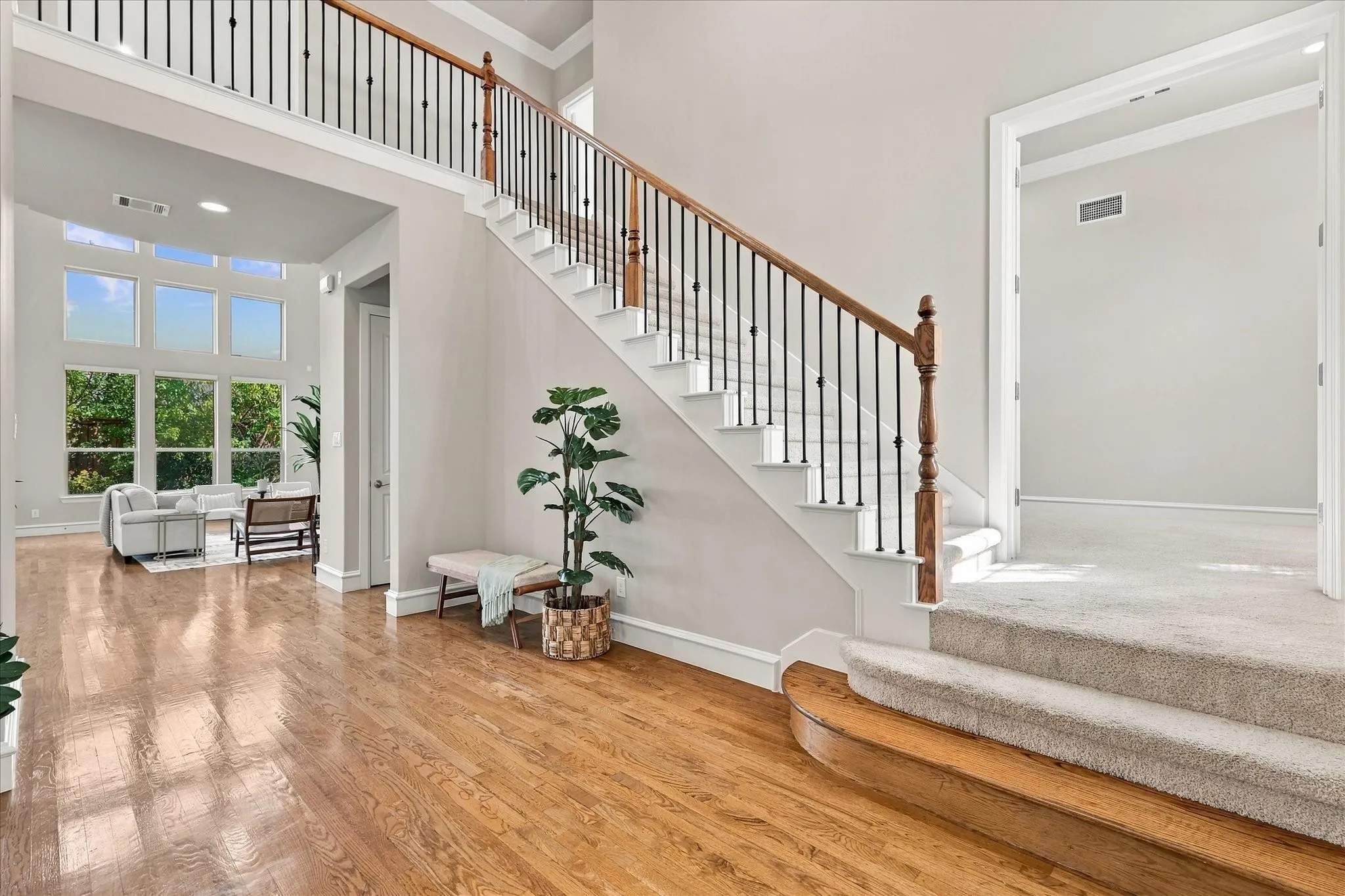 Beautiful entry with wood floors and rod iron staircase