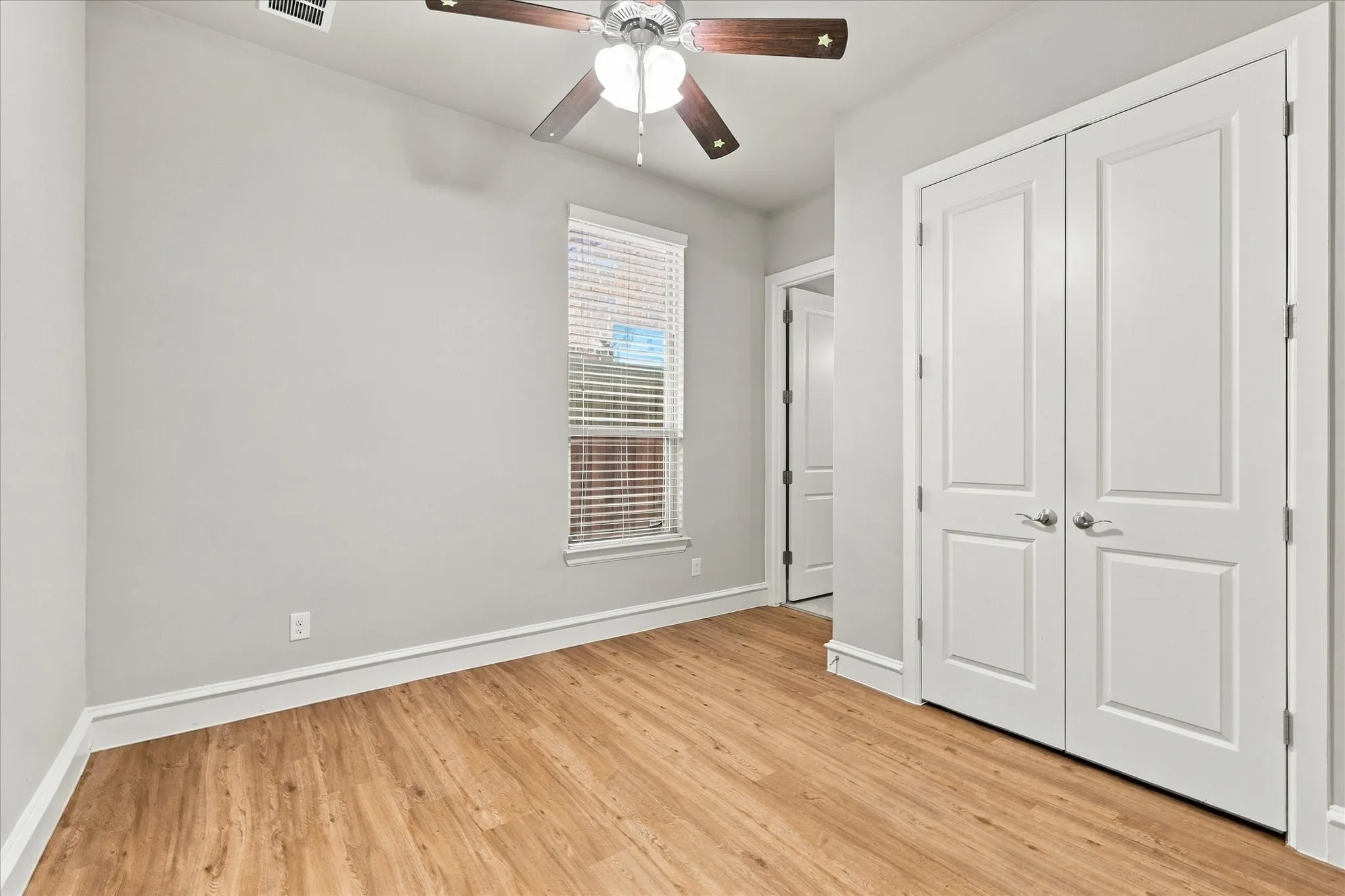 First floor secondary bedroom with wood floors and adjacent full bath