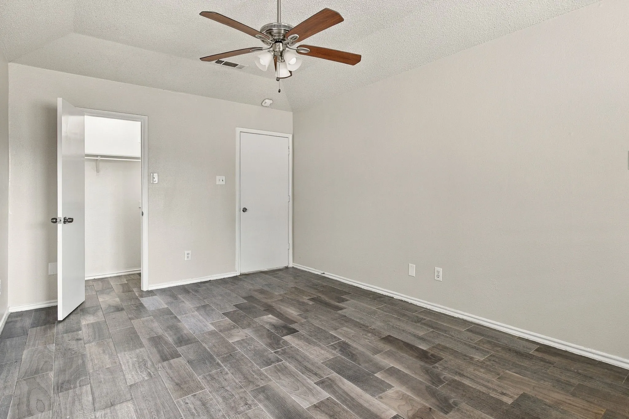 Wood-finish flooring throughout, ceiling fan with integrated lighting, recessed lighting, and a built-in closet with hanging rod