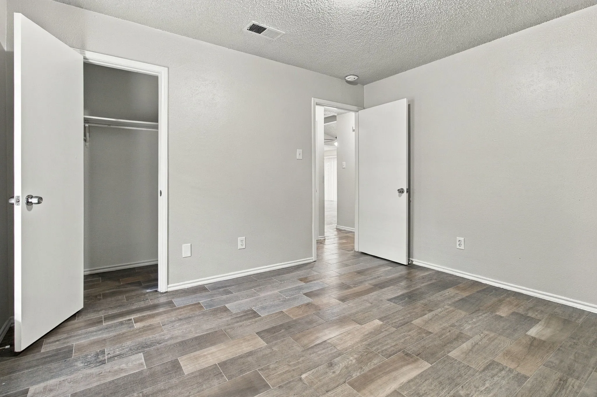 Wood-finish plank flooring, light neutral wall paint, and white trim