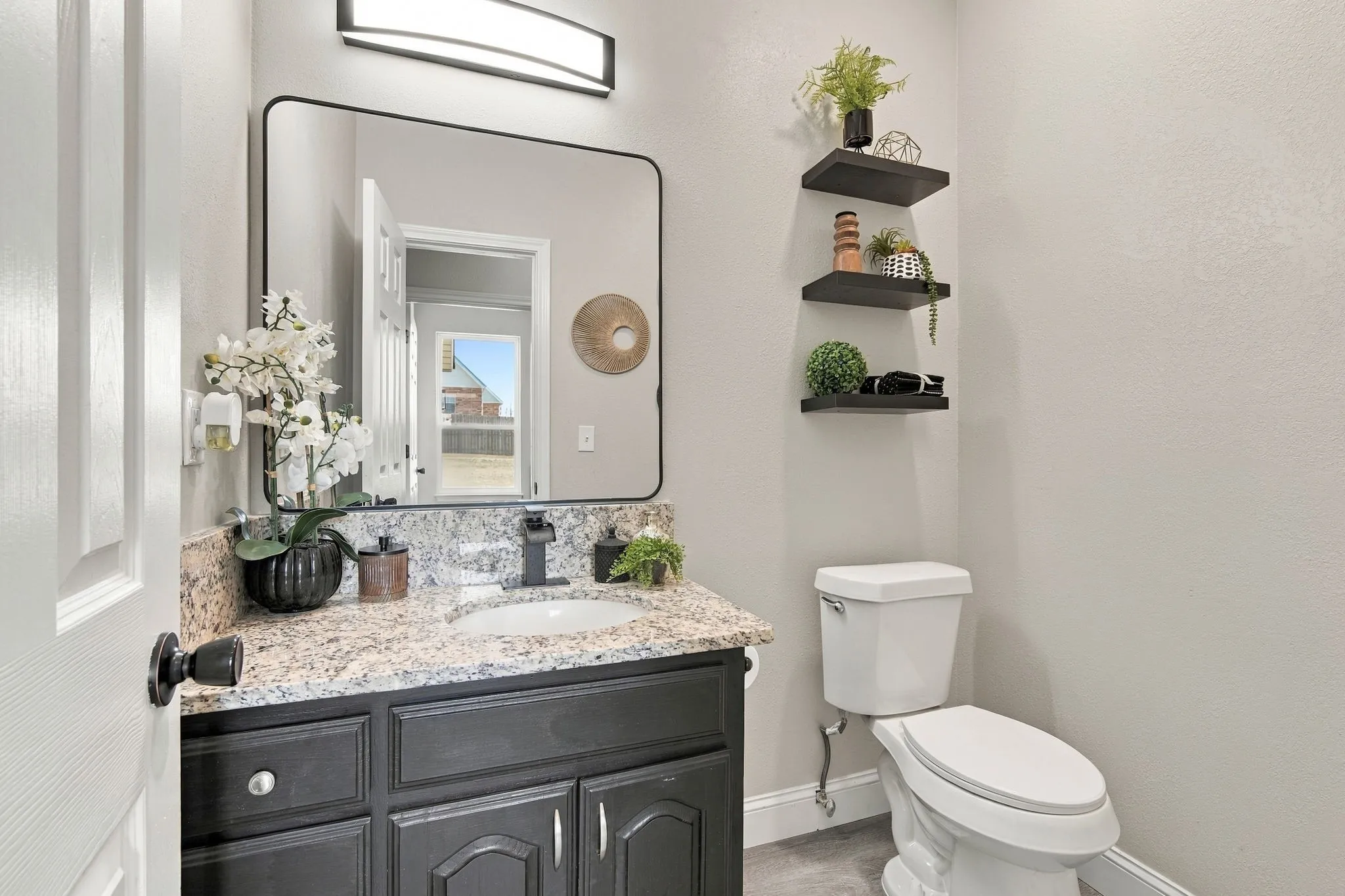 Half Bath in the hallway across from laundry room between the kitchen and main floor office