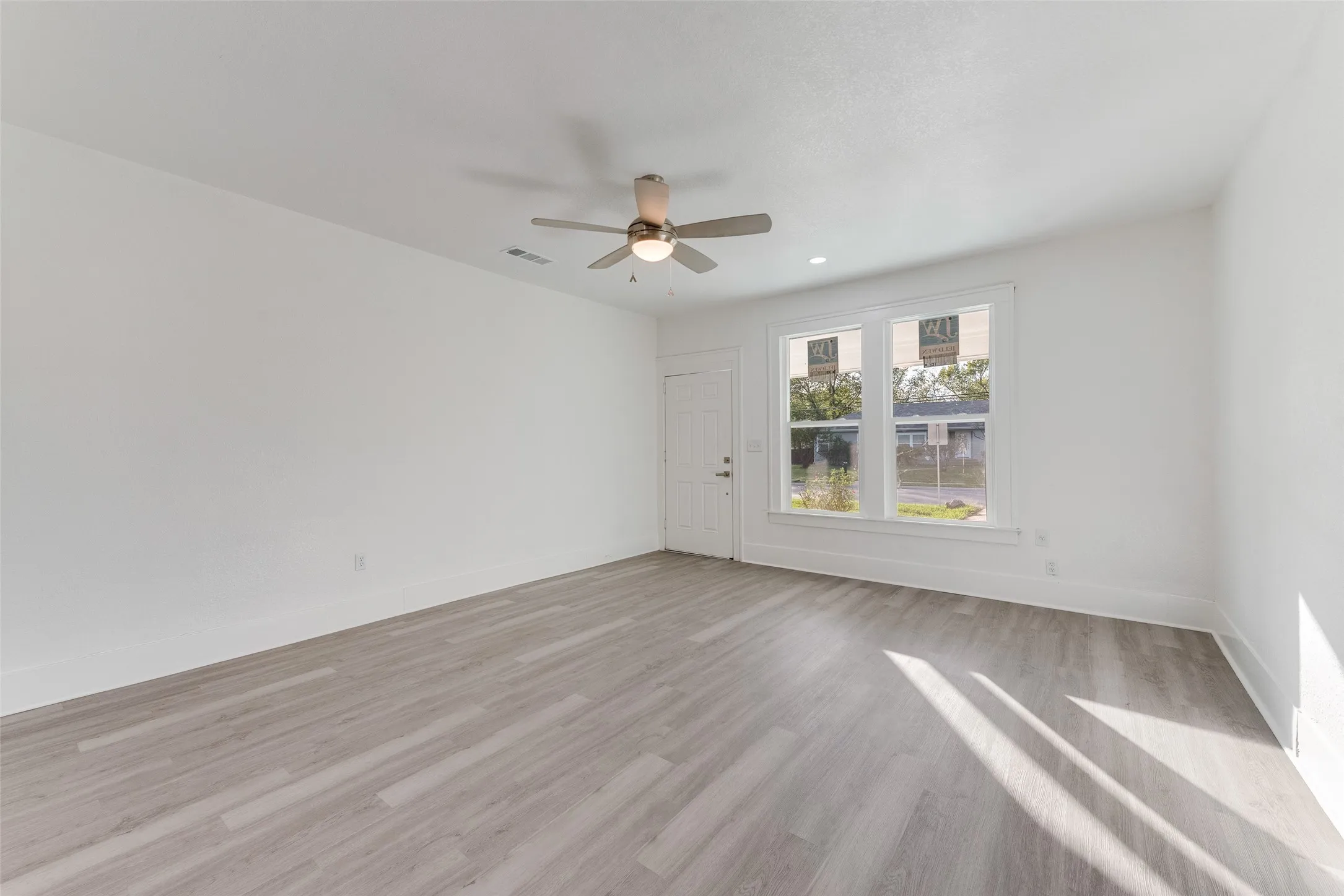 Light wood-finish flooring with white baseboards